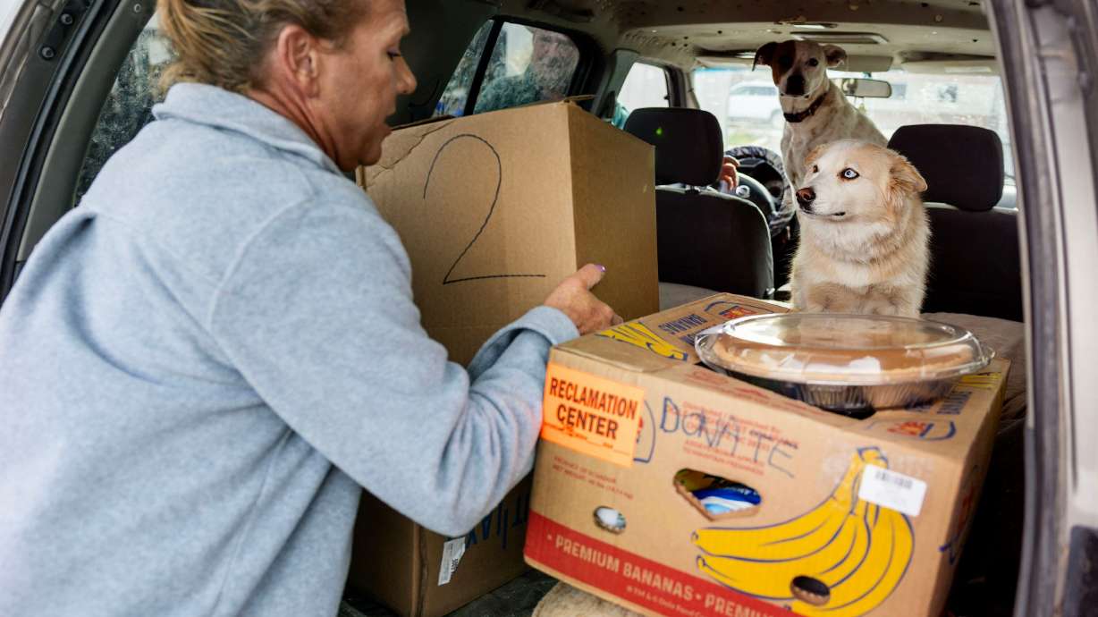 Michael Anderson places a box of food into a car during the Salt Lake City Mission’s annual “Christmas Food Box Giveaway” in Salt Lake City on Monday.