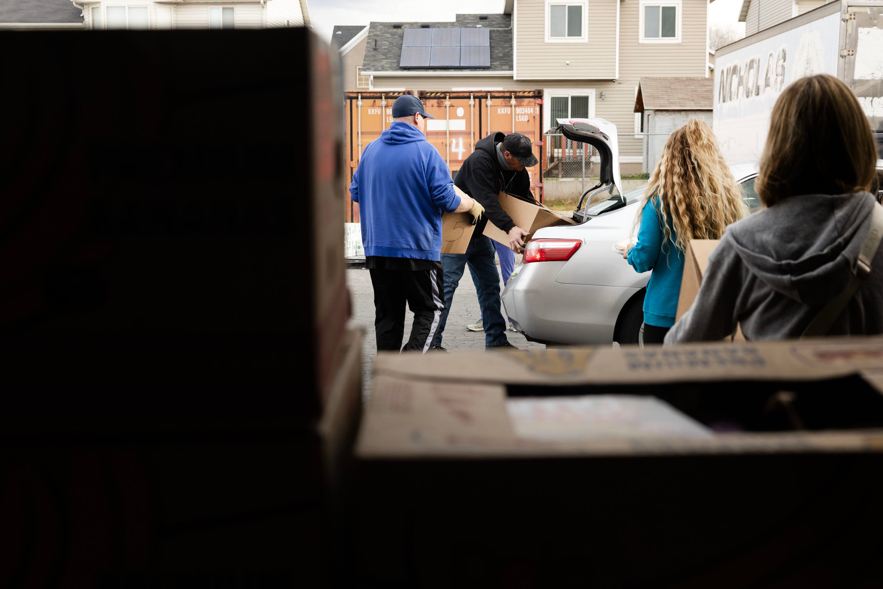 Volunteers and Salt Lake City Mission program participants place boxes of food in a car during the mission’s annual “Christmas Food Box Giveaway” in Salt Lake City on Monday.