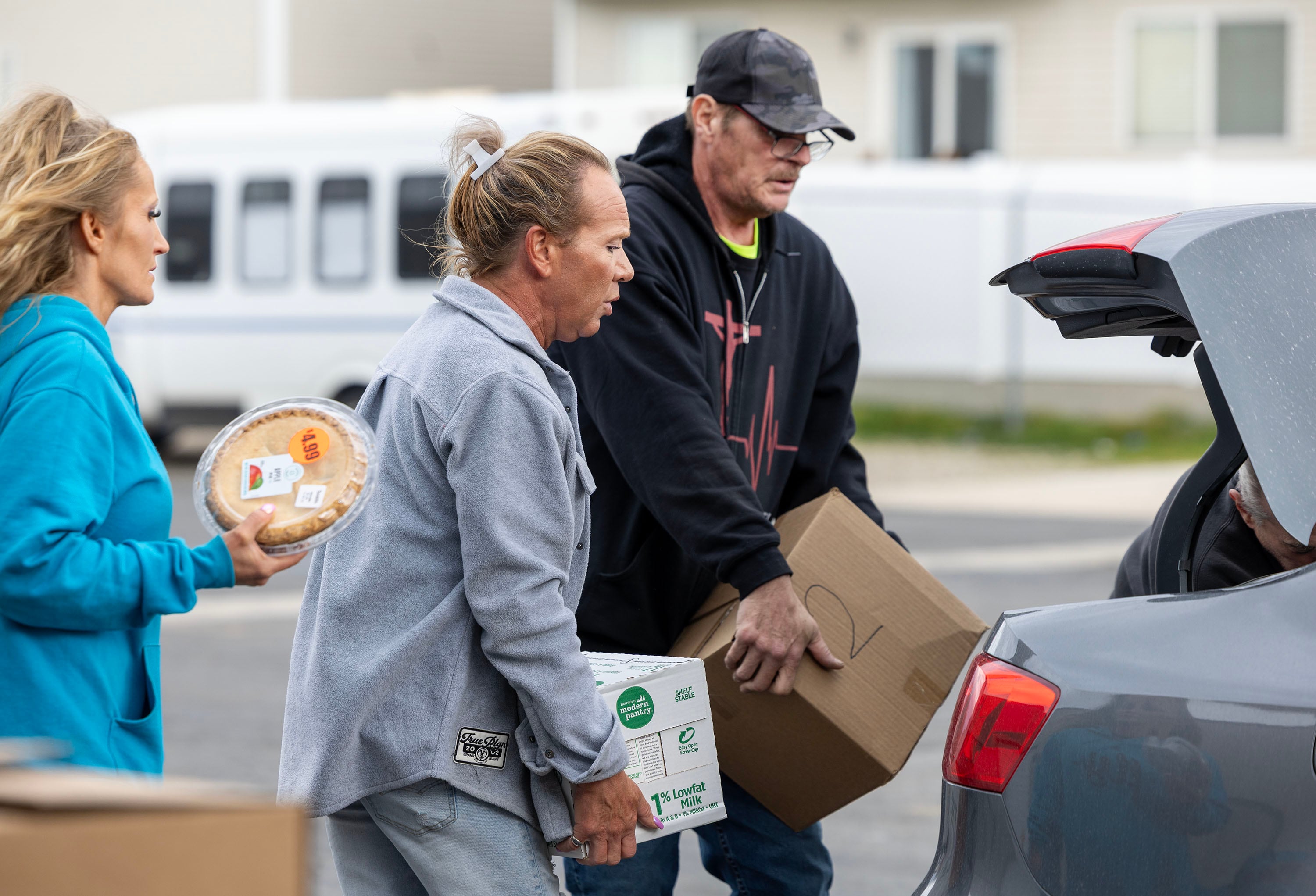 Volunteers Jessica Fairbanks, Michael Anderson and Danny Klatts place food in a car during the Salt Lake City Mission’s annual “Christmas Food Box Giveaway” in Salt Lake City on Monday.