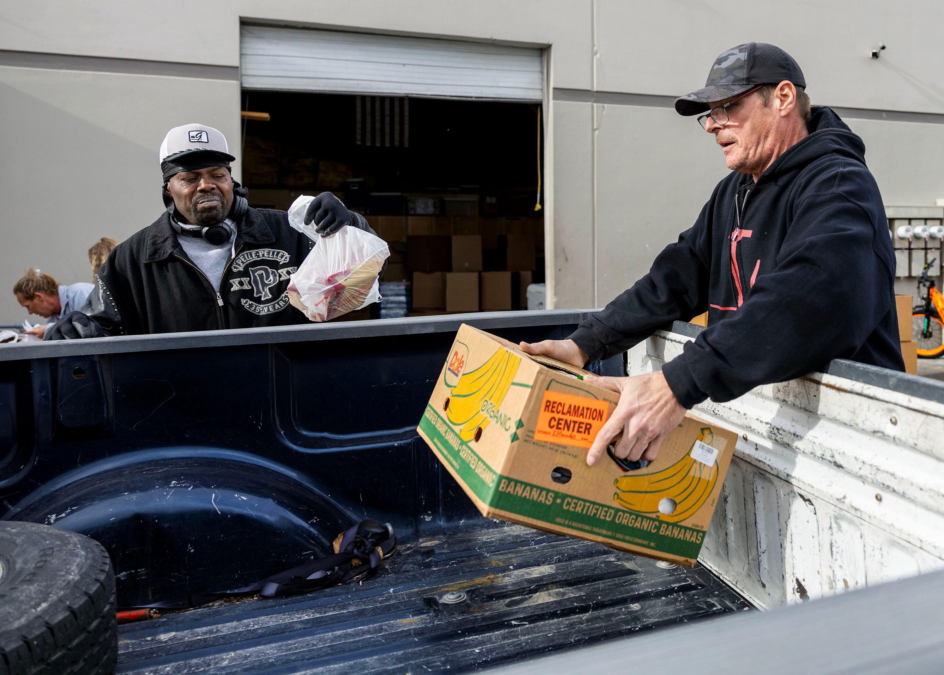 Volunteers Arthur Dulaney and Danny Klatts place food into a car during the Salt Lake City Mission’s annual “Christmas Food Box Giveaway” in Salt Lake City on Monday.
