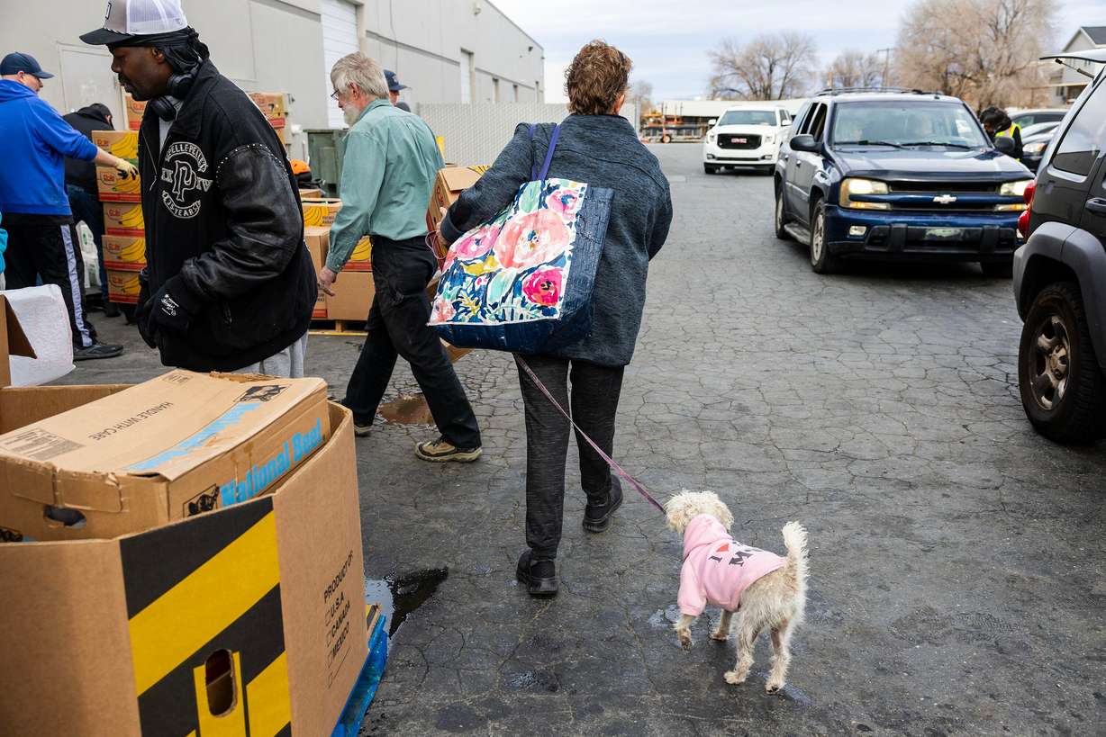 A woman leaves with a box of food during the Salt Lake City Mission’s annual “Christmas Food Box Giveaway” in Salt Lake City on Monday.
