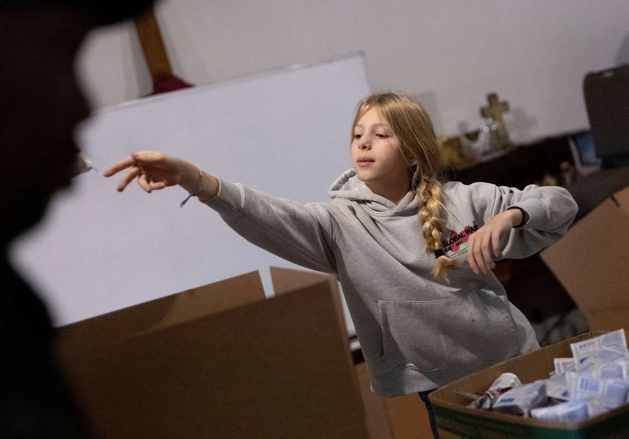 Anna Fisher of Salt Lake City fills food boxes during the Salt Lake City Mission’s annual “Christmas Food Box Giveaway” in Salt Lake City on Monday.