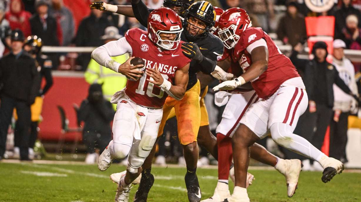 Arkansas quarterback Taylen Green (10) is sacked by Missouri defensive end Damon Wilson II, center, during the second half of an NCAA college football game Saturday, Nov. 29, 2025, in Fayetteville, Ark.