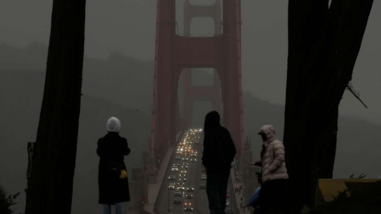 People look toward traffic on the Golden Gate Bridge from the Golden Gate Overlook in San Francisco, Tuesday.