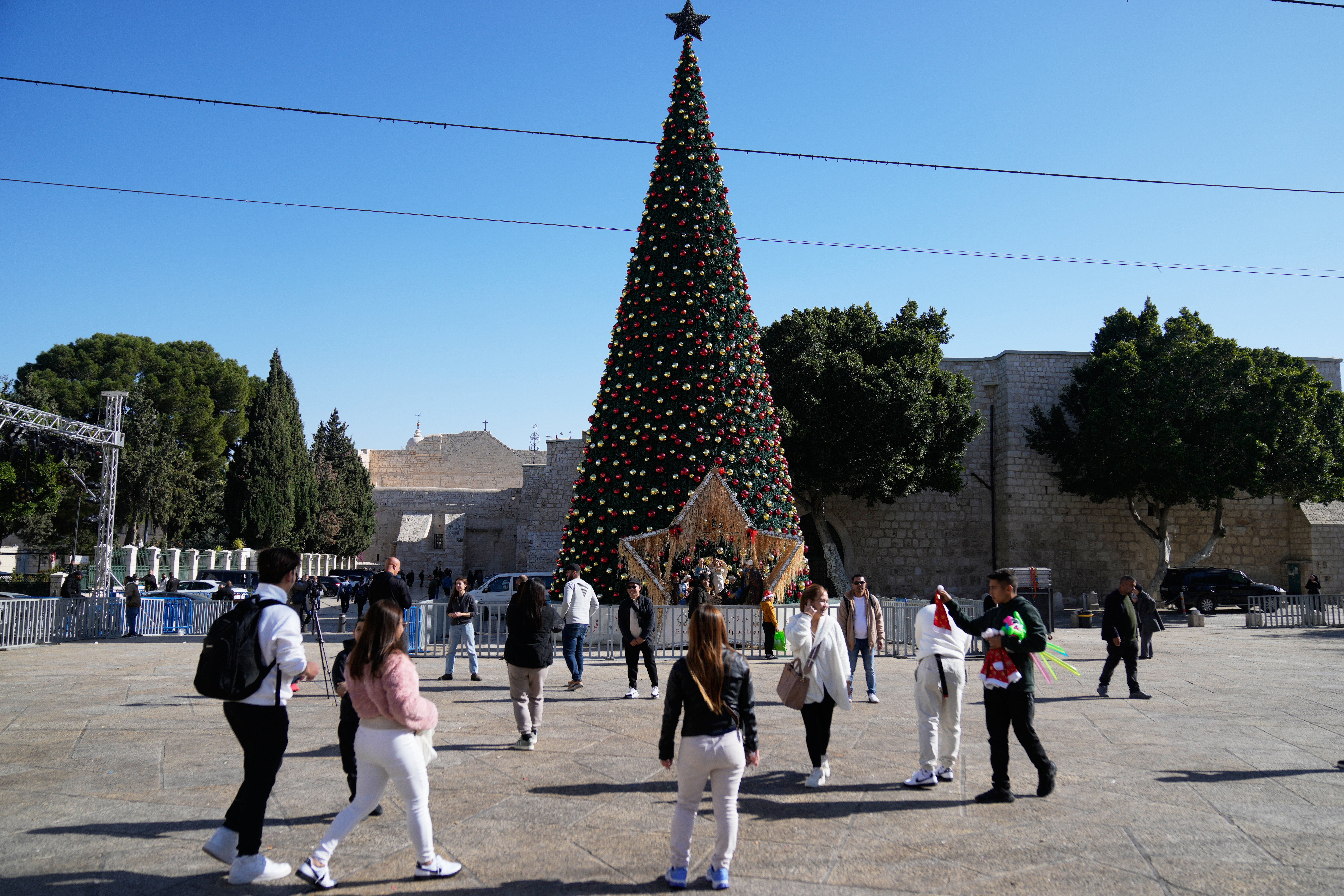 Palestinians and tourists visit the Manger Square and the Church of the Nativity, believed to be Jesus' birthplace, ahead of Christmas, in the West Bank city of Bethlehem, Tuesday, Dec. 23, 2025.