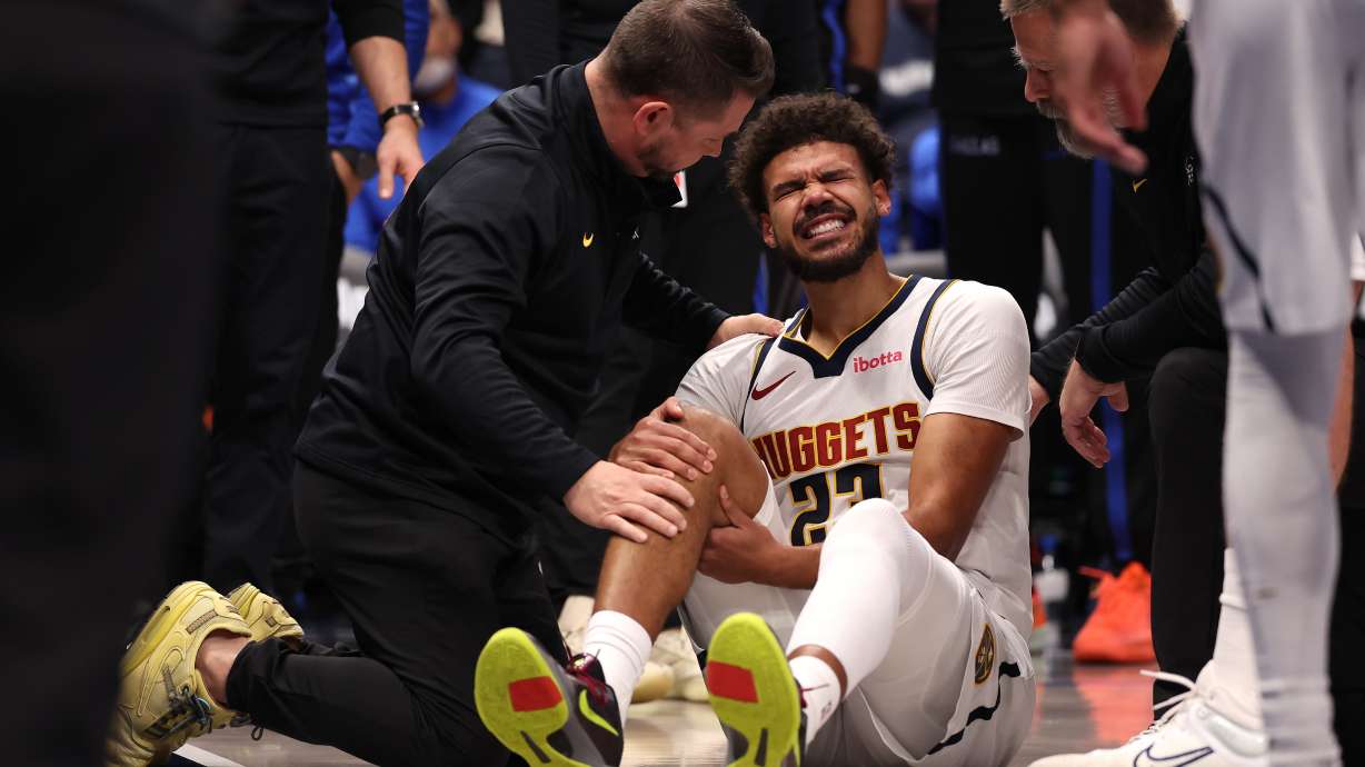 Denver Nuggets forward Cameron Johnson reacts after sustaining an injury during the fourth quarter of an NBA basketball game against the Dallas Mavericks Tuesday, Dec. 23, 2025, in Dallas.