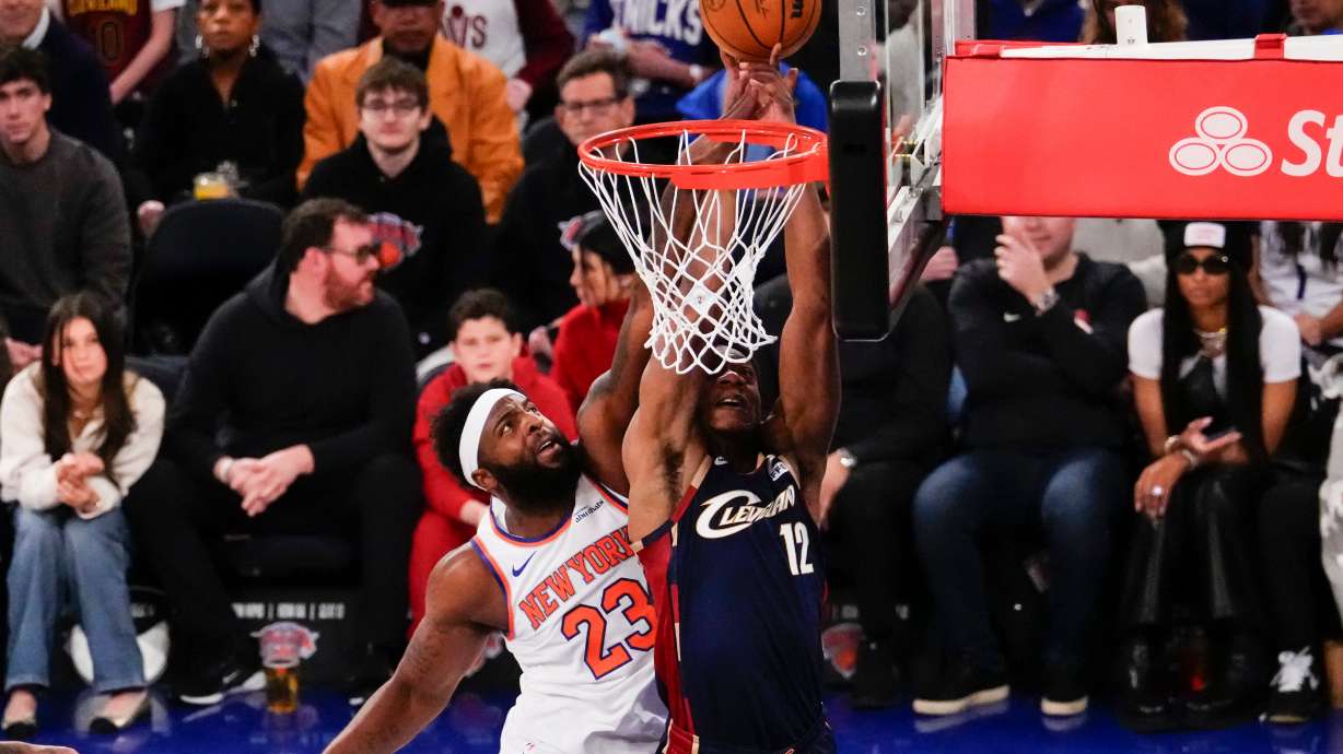 New York Knicks center Mitchell Robinson (23) blocks Cleveland Cavaliers forward De'Andre Hunter (12) during the first half of an NBA basketball game, Thursday, Dec. 25, 2025, in New York.