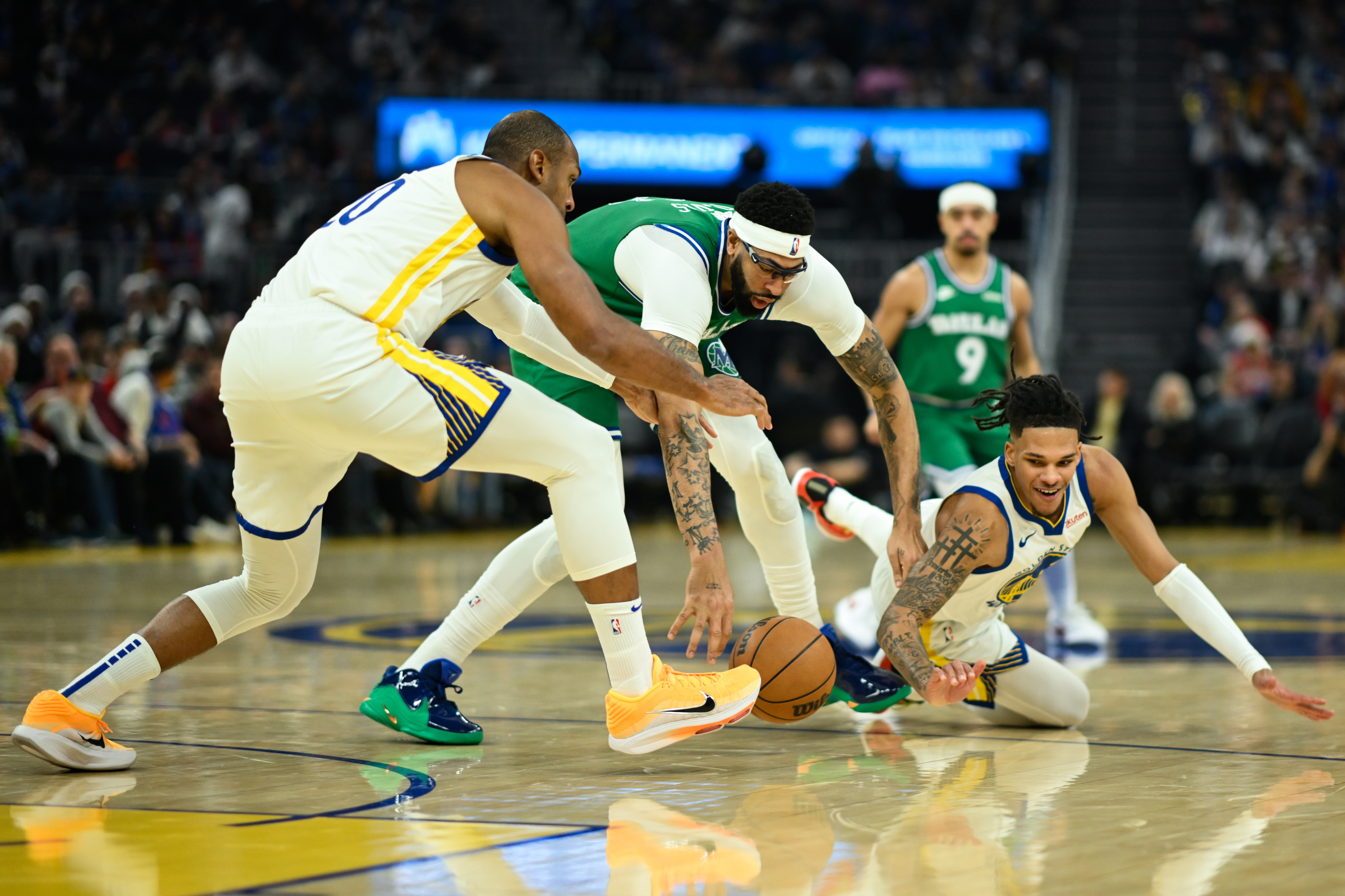 Dallas Mavericks forward Anthony Davis, center, Golden State Warriors center Al Horford, left, and guard Will Richard, right, reach for a loose ball during the first half of an NBA basketball game Thursday, Dec. 25, 2025, in San Francisco.