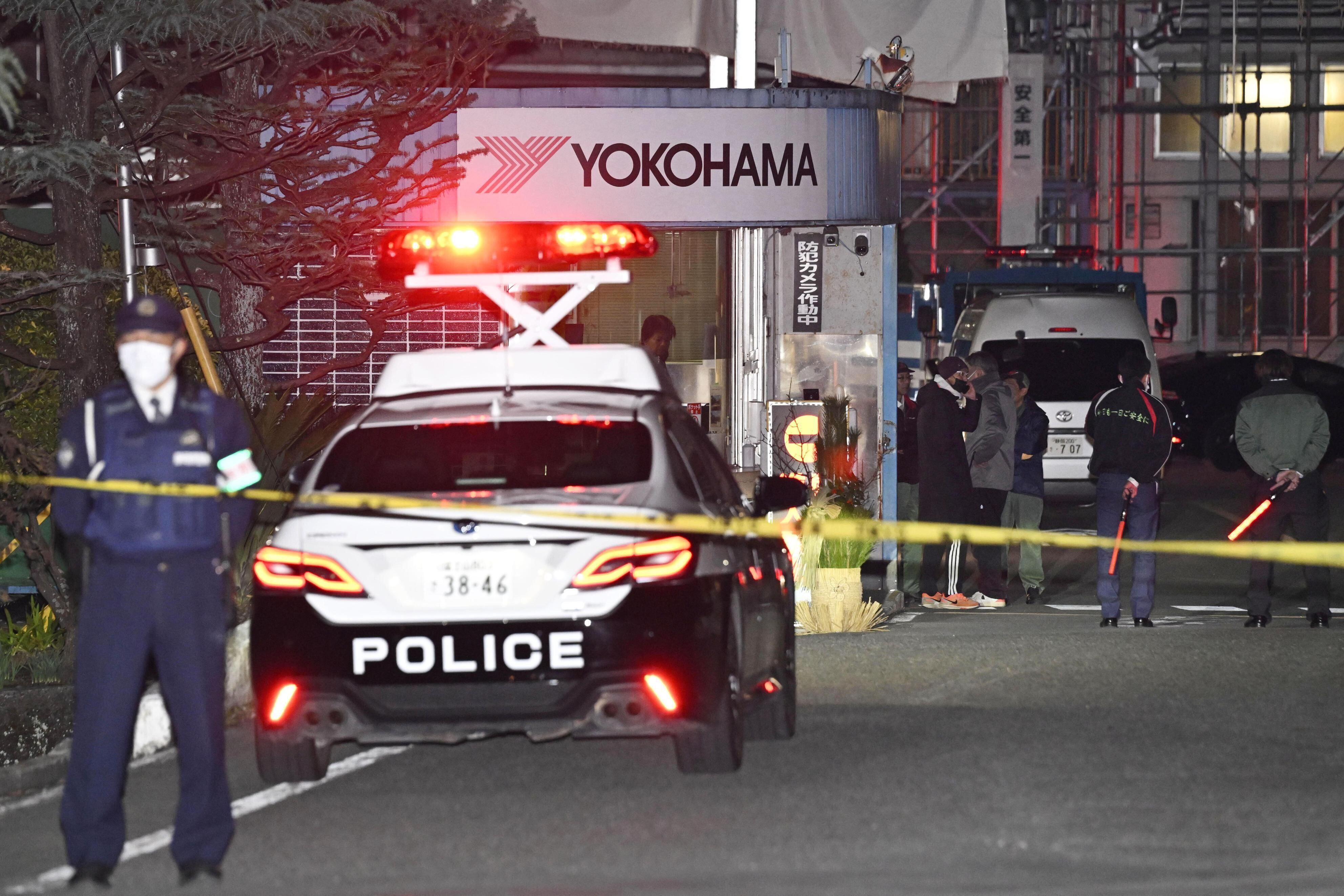 Police officers stand guard at the scene of a stabbing at the Yokohama Rubber Company in Mishima, west of Tokyo, Friday.