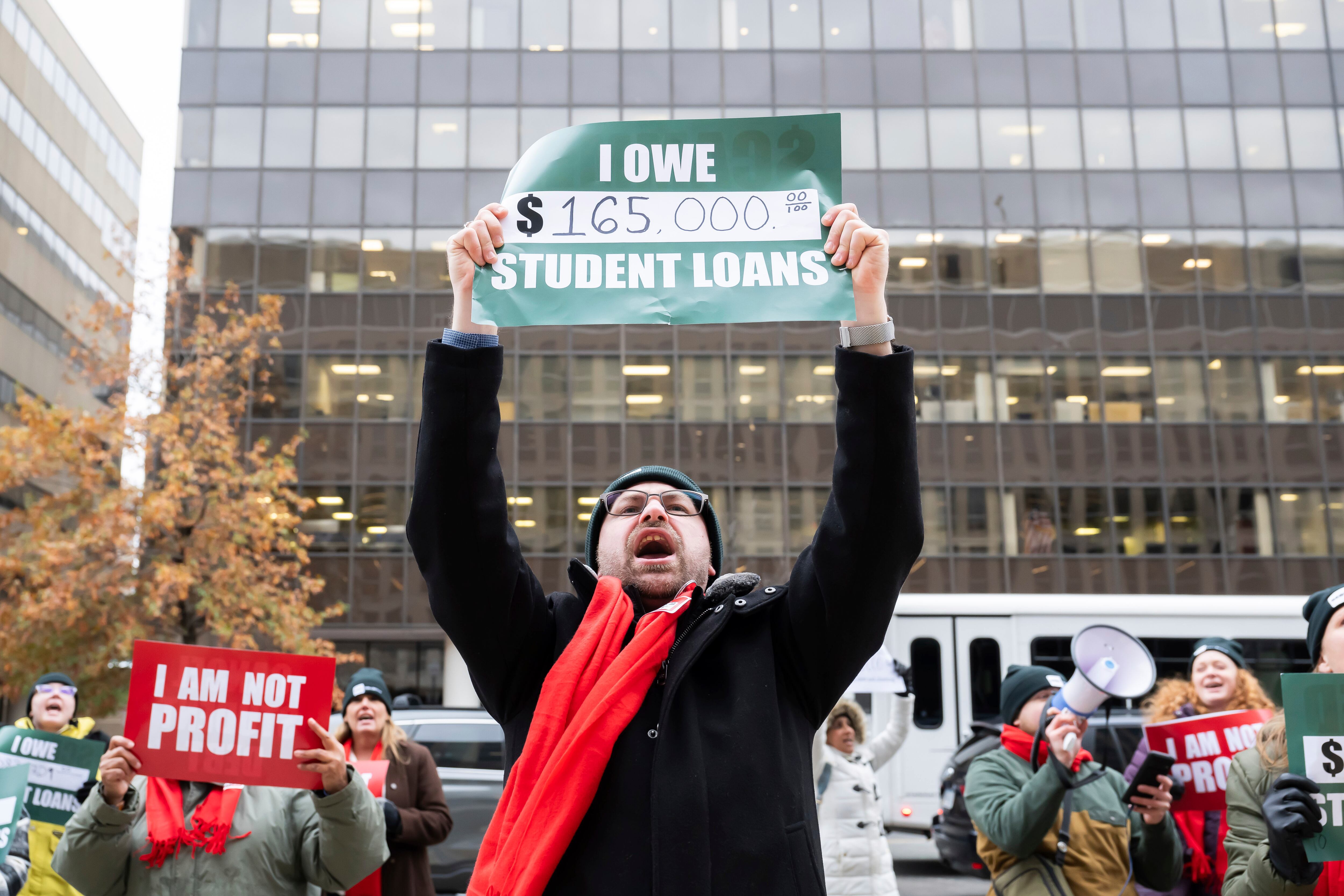 Debt Collective student loan borrowers lead chants in protest outside of the Department of Education, urging the administration in its last few weeks to eliminate crushing debt for those defrauded by predatory for-profit colleges on Dec. 4, 2024, in Washington.
