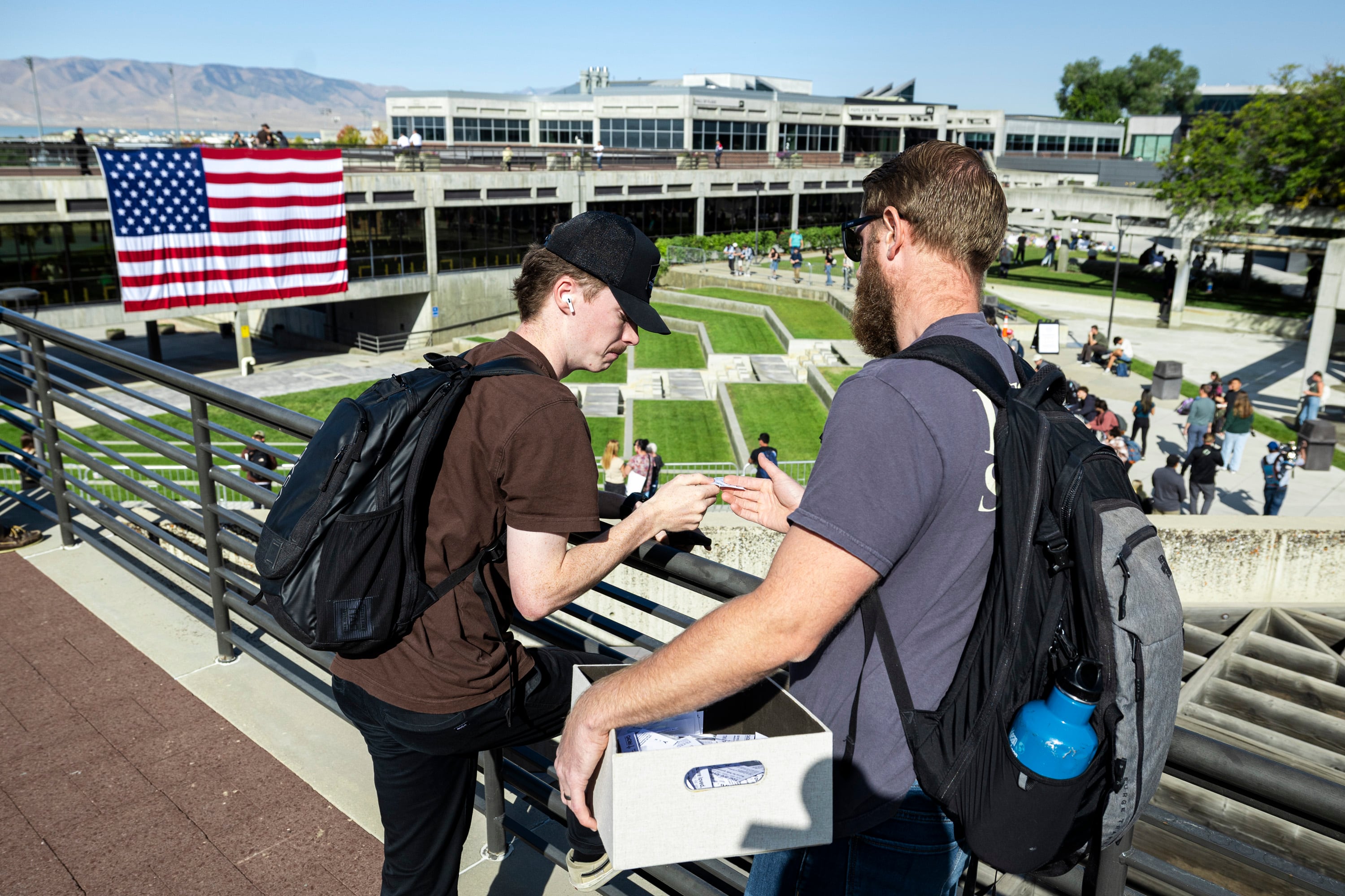Pastor Brendon Scoggin, of the First Baptist Church of Provo, hands a card of encouragement to Max Dunlop, a sophomore at Utah Valley University studying construction management, in the courtyard on the campus of UVU in Orem on Sept. 17, as students return to campus following the shooting death of Charlie Kirk in the courtyard a week prior.
