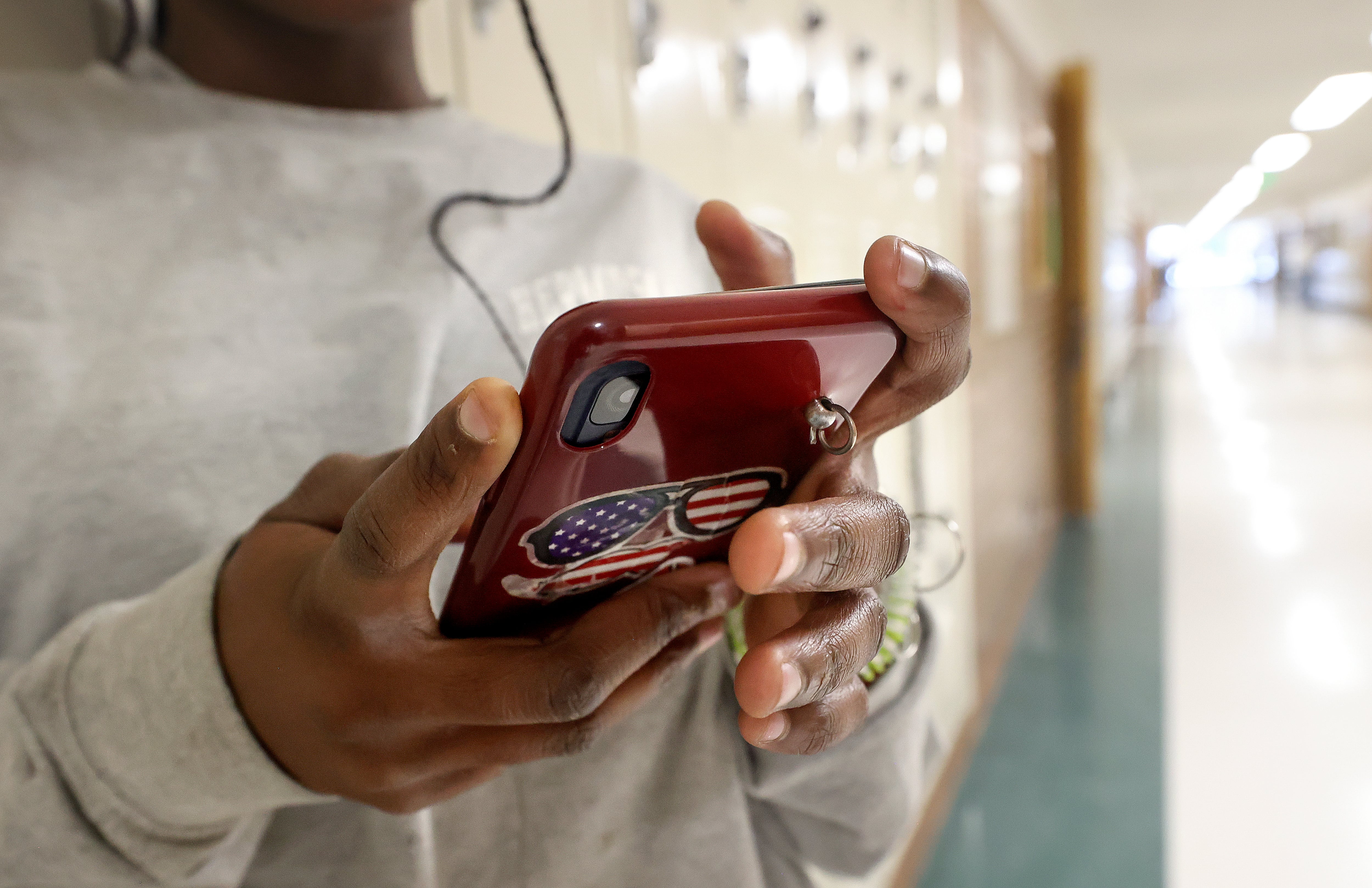 An eighth grader uses their cellphone after school at Evergreen Junior High School in Millcreek on Jan. 10, 2024.