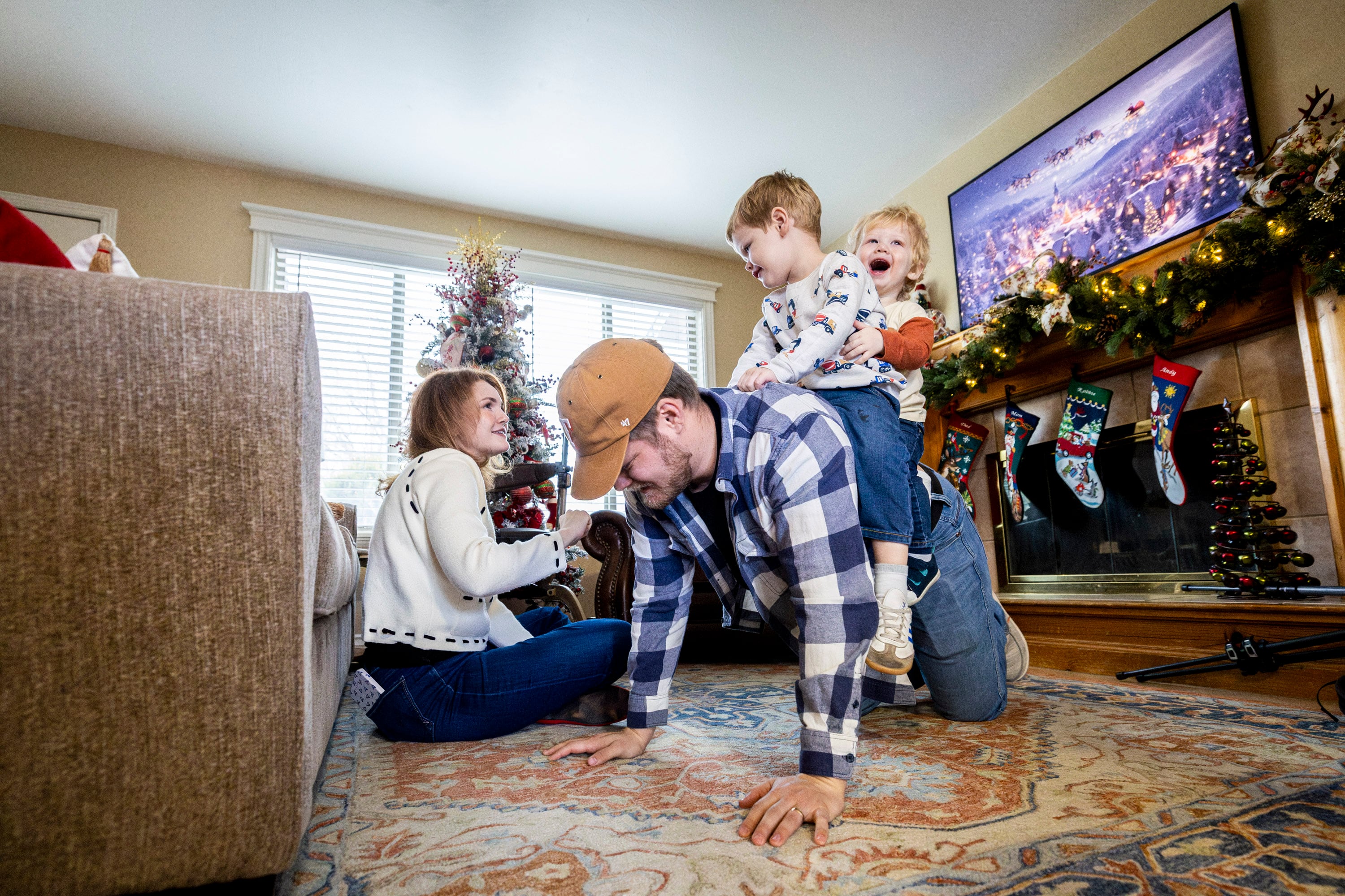 From left, Tiffany Fransen looks to her husband, Alex, as their two children, Robbie, 3, and Andy, 1, “play horsey” and ride on his back at their family's home in Highland on Dec. 17.