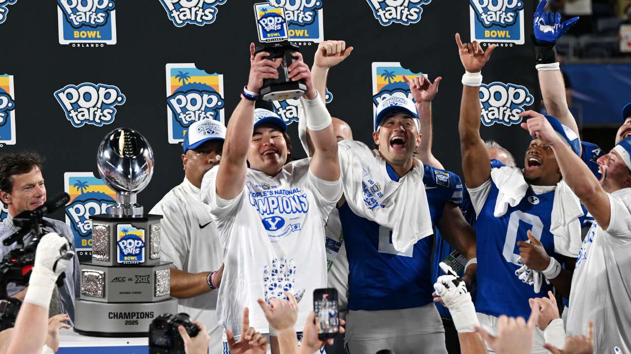 BYU Cougars quarterback Bear Bachmeier (47) holds the MVP trophy up as the BYU Cougars celebrate their 25-21 win over the Georgia Tech Yellow Jackets in the Pop-Tarts Bowl in Orlando on Saturday, Dec. 27, 2025.