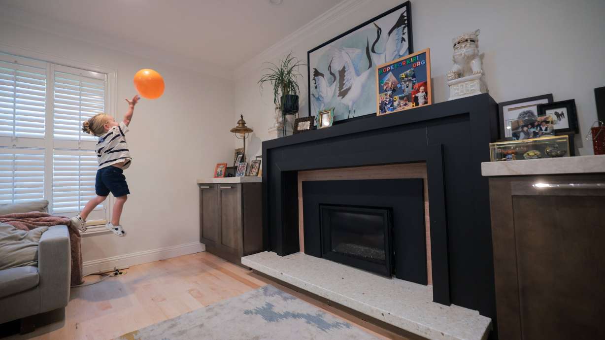 Kiri Duke-Rosati, 3, leaps off the couch as he plays “keepy uppy” with a balloon in his home in Holladay on Aug. 4.