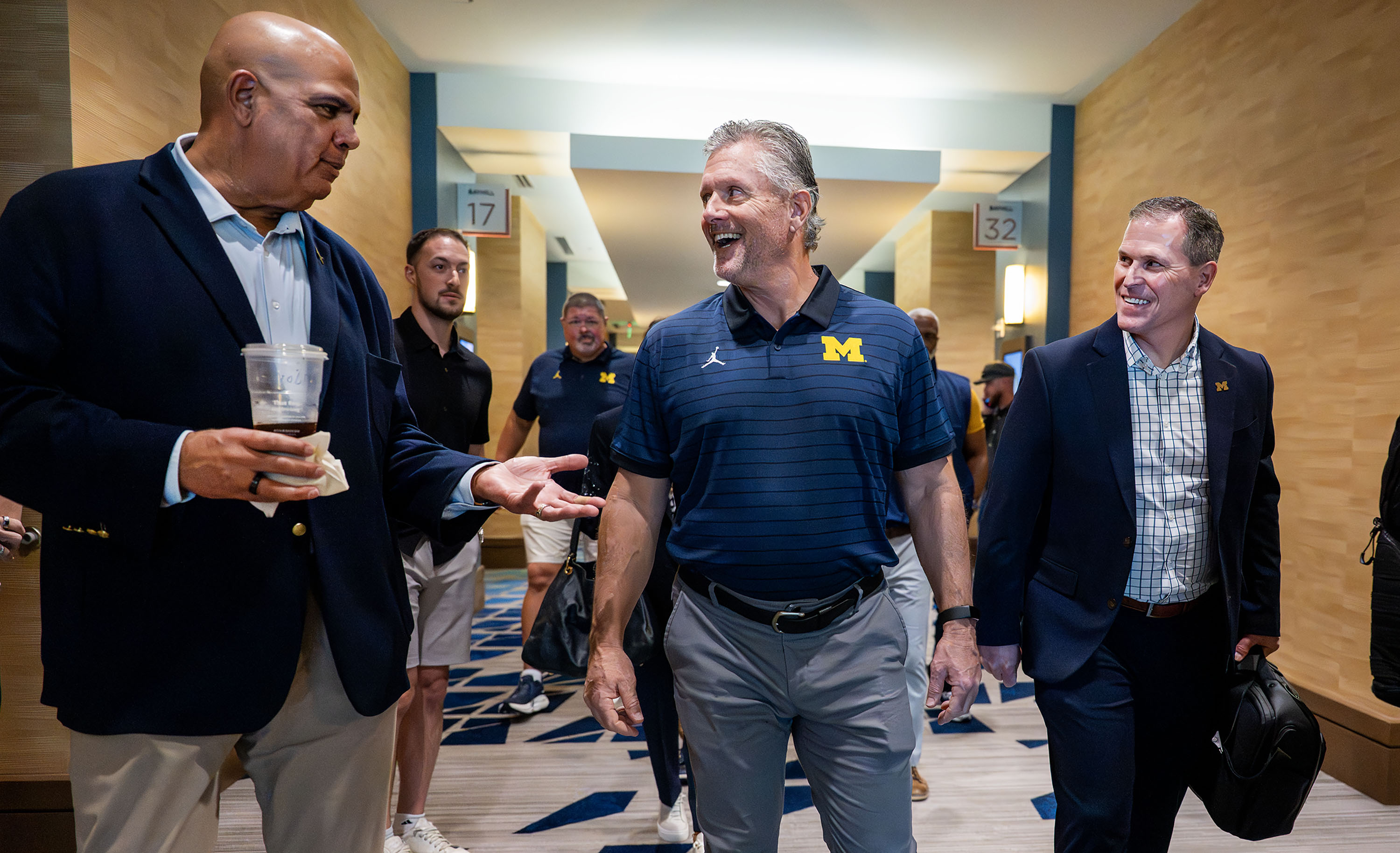 Michigan athletic director Warde Manuel, left, talks with new Wolverines Head Coach Kyle Whittingham after a press conference at the Hyatt Regency in Orlando, Florida, on Sunday, Dec. 28, 2025.