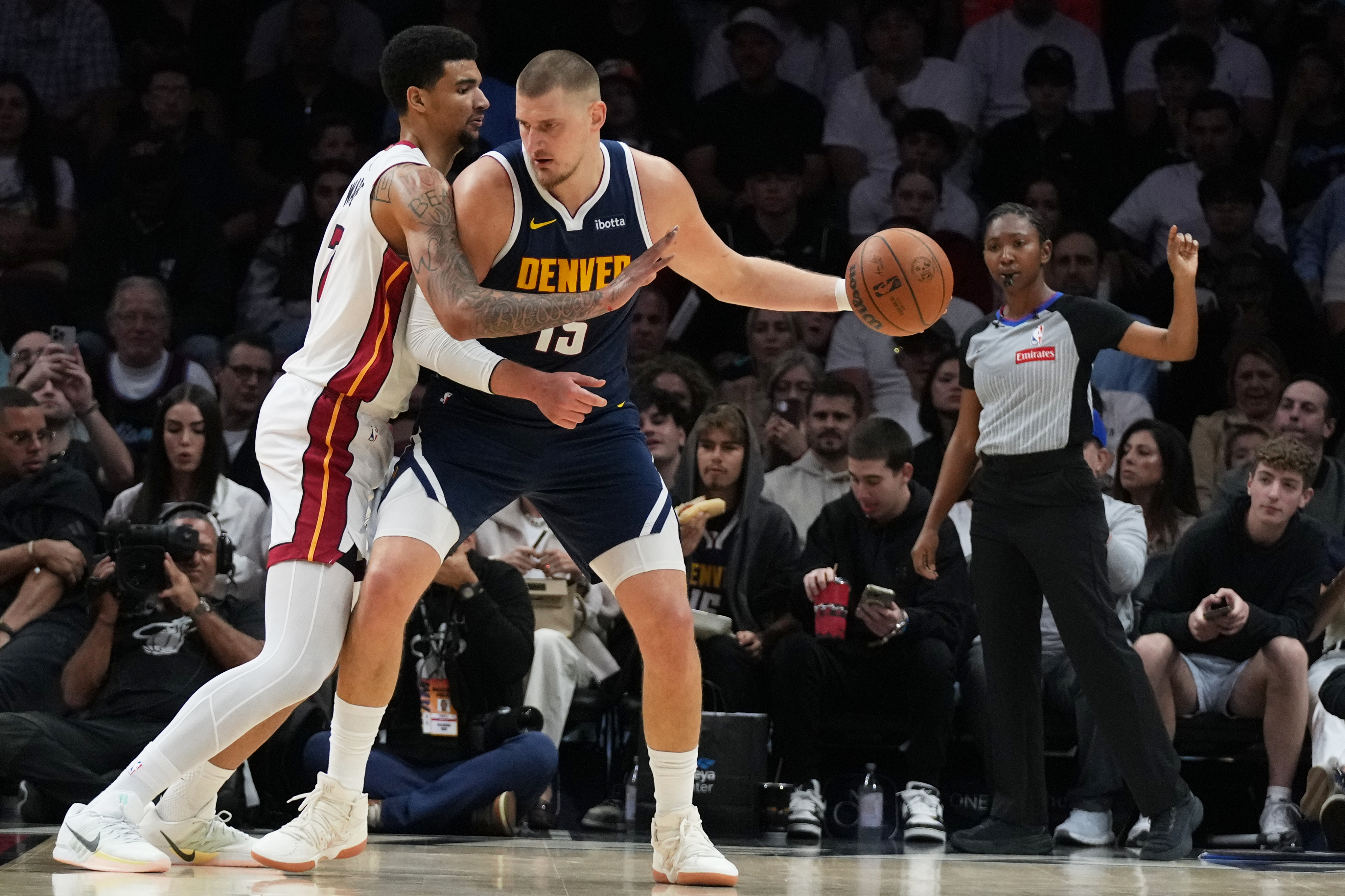 Miami Heat center Kel'El Ware, left, defends Denver Nuggets center Nikola Jokic (15) during the first half of an NBA basketball game, Monday, Dec. 29, 2025, in Miami.