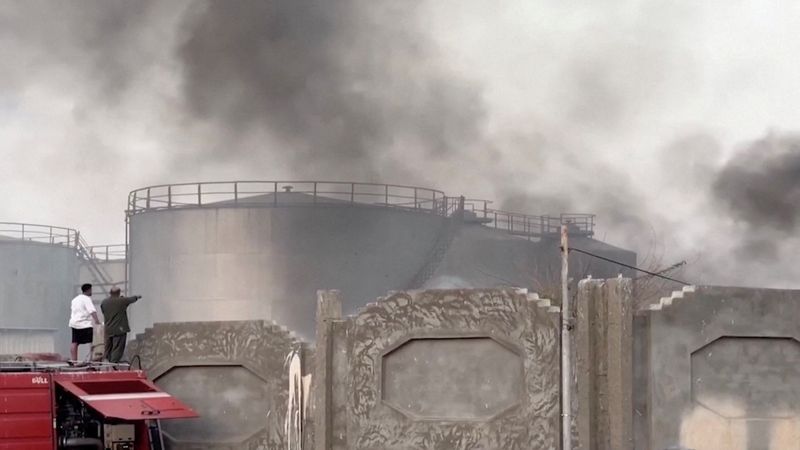 A person gestures towards smoke rising in the aftermath of a Saudi-led coalition airstrike in Yemen's southern port of Mukalla, in this screengrab from a handout video obtained by Reuters on Tuesday. The United Arab Emirates announced it would pull all remaining forces out of Yemen.