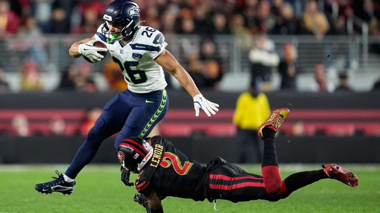 Seattle Seahawks running back Zach Charbonnet (26) runs against San Francisco 49ers cornerback Deommodore Lenoir (2) during the second half of an NFL football game in Santa Clara, Calif., Saturday, Jan. 3, 2026.