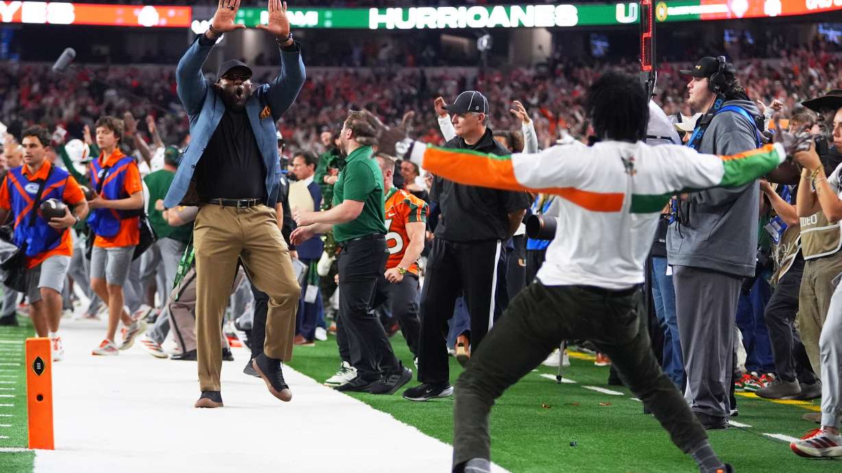 Former NFL football players Ray Lewis, left, and Michael Irvin react after Miami running back Charmar Brown, not visible, scored a rushing touchdown during the second half of the Cotton Bowl College Football Playoff quarterfinal game against Ohio State Wednesday, Dec. 31, 2025, in Arlington, Texas.