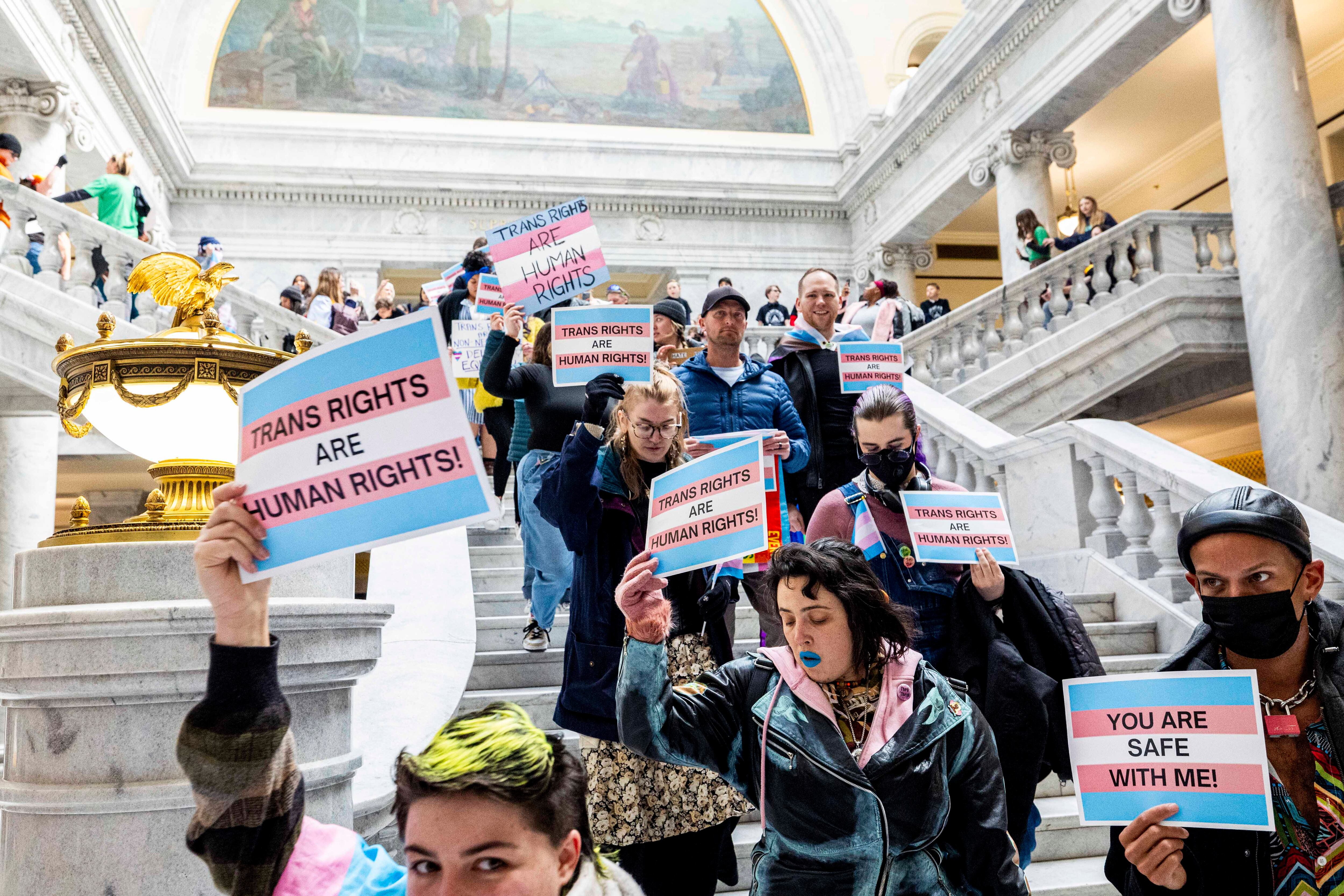 Protesters walk down the steps inside the rotunda during a demonstration supporting transgender rights held at the Utah State Capitol in Salt Lake City on the first day of the legislative session on Jan. 21, 2025.
