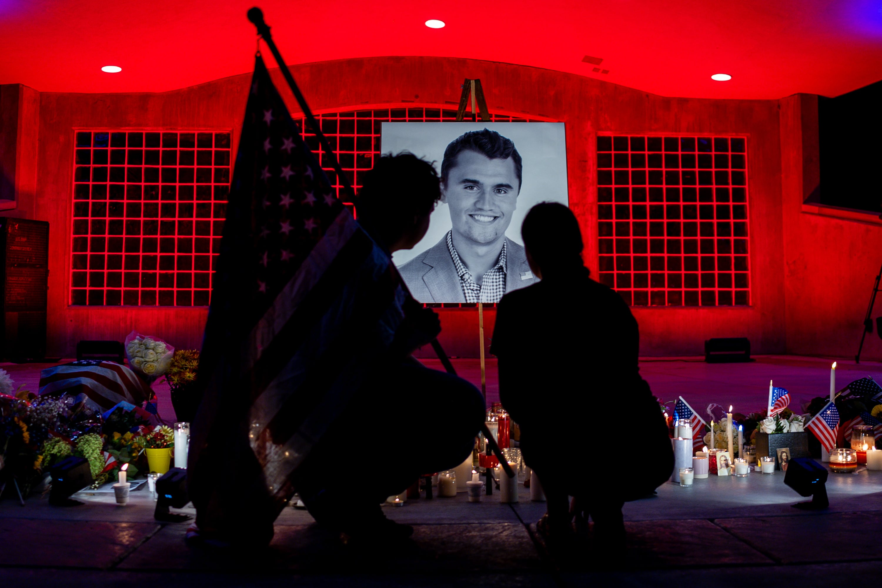 Andrew Parry, left, and his fiancee, Anja Albrecht, right, kneel to grieve in front of a photo of Charlie Kirk at a vigil for Charlie Kirk, the CEO and co-founder of the conservative youth organization Turning Point USA who was fatally shot during Turning Point’s visit to Utah Valley University in Orem on Sept. 10, 2025, at City Center Park in Orem on Sept. 11, 2025.