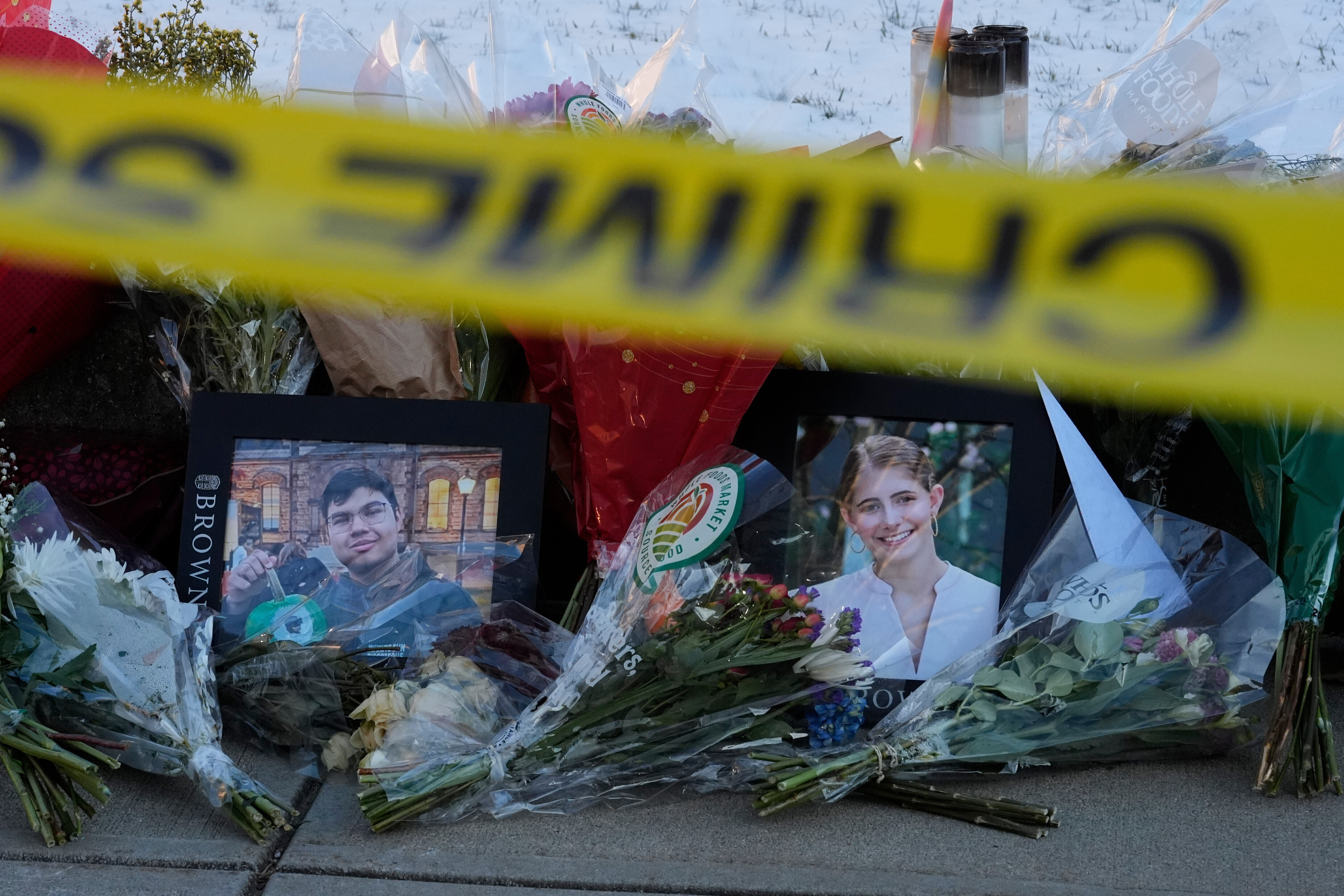 Photos of Brown University shooting victims MukhammadAziz Umurzokov, left, and Ella Cook, lay on a makeshift memorial outside the Engineering Research Center, Dec. 16, in Providence, R.I. The Department of Justice revealed on Tuesday that the attack had been planned for years.
