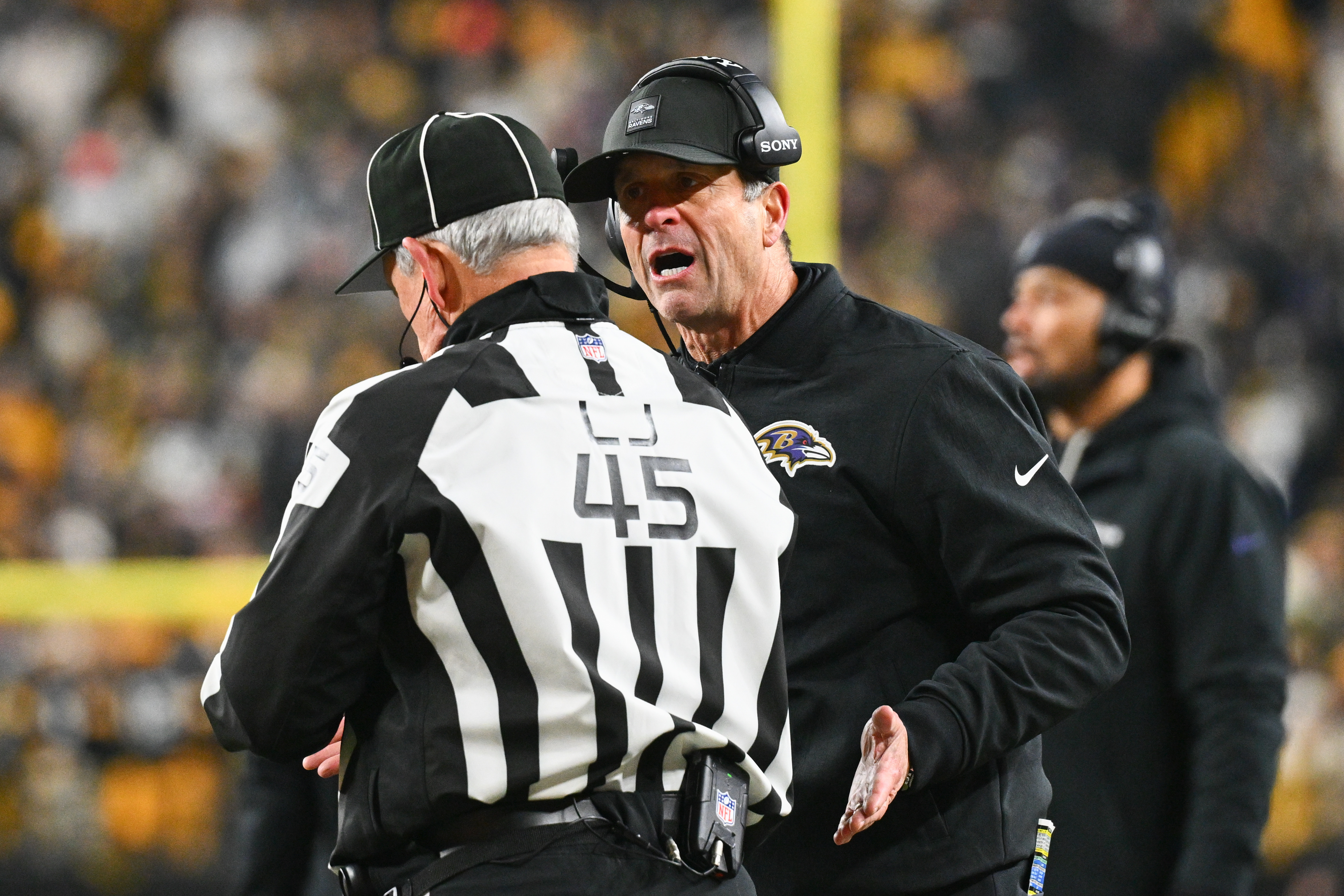 Baltimore Ravens head coach John Harbaugh talks with an offical during the second half of an NFL football game against the Pittsburgh Steelers, Sunday, Jan. 4, 2026, in Pittsburgh.