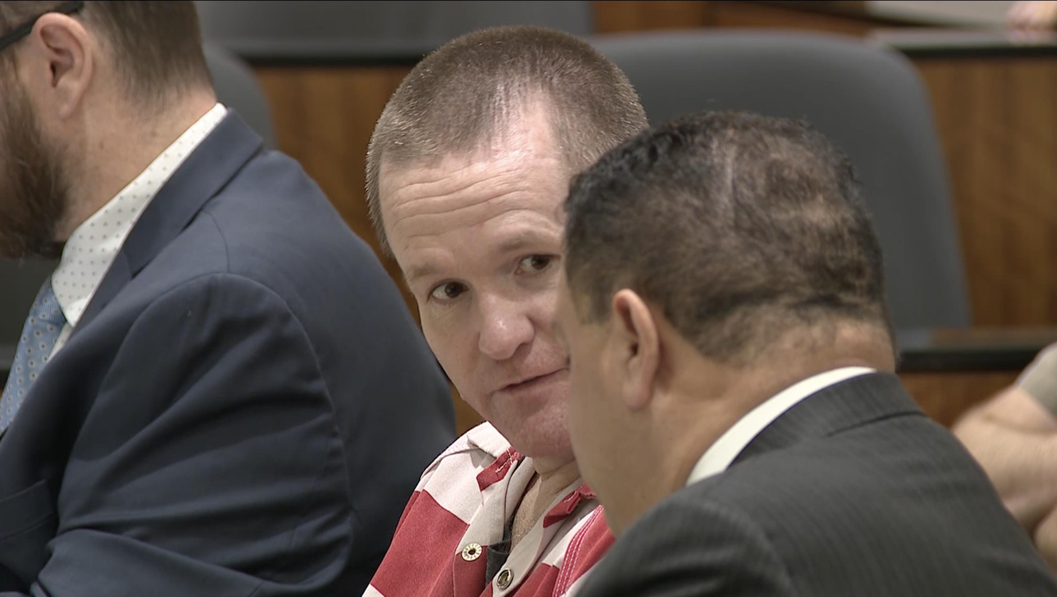 Michael Jayne speaks with his attorney during his preliminary hearing on Tuesday. He is charged with capital murder in the death of a Santaquin police officer.