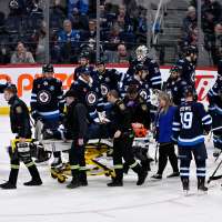 Jets D Fleury alert, moving extremities after taken off ice on stretcher after collision with boards