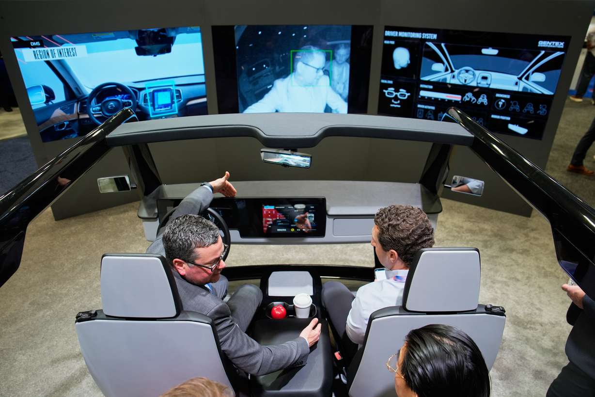 People experience a Gentex Corporation driver and in-camera monitoring system exhibit during the CES tech show Tuesday, in Las Vegas. Artificial intelligence dominated this year's CES.