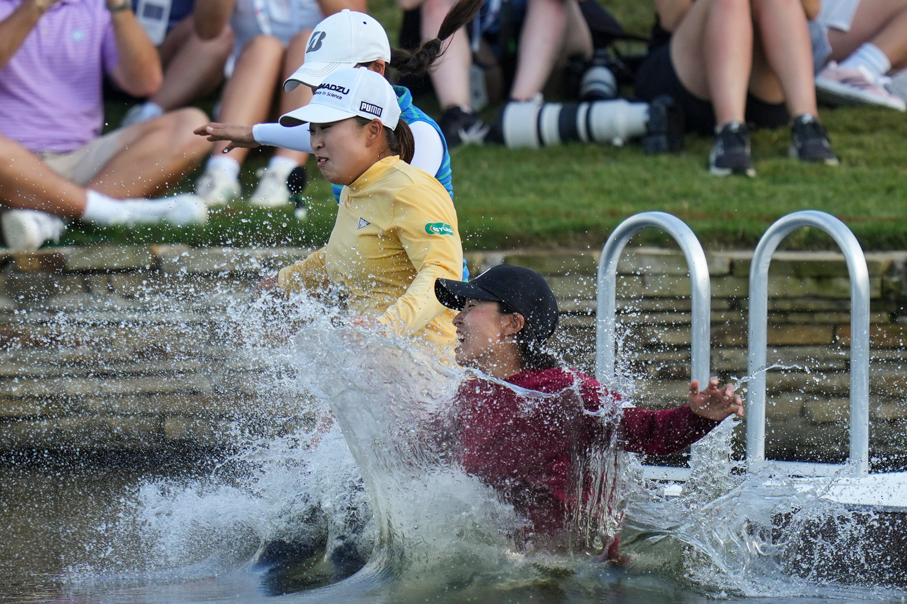 FILE -Mao Saigo, of Japan, in yellow, jumps into the water after winning the Chevron Championship LPGA golf tournament April 27, 2025, in The Woodlands, Texas.
