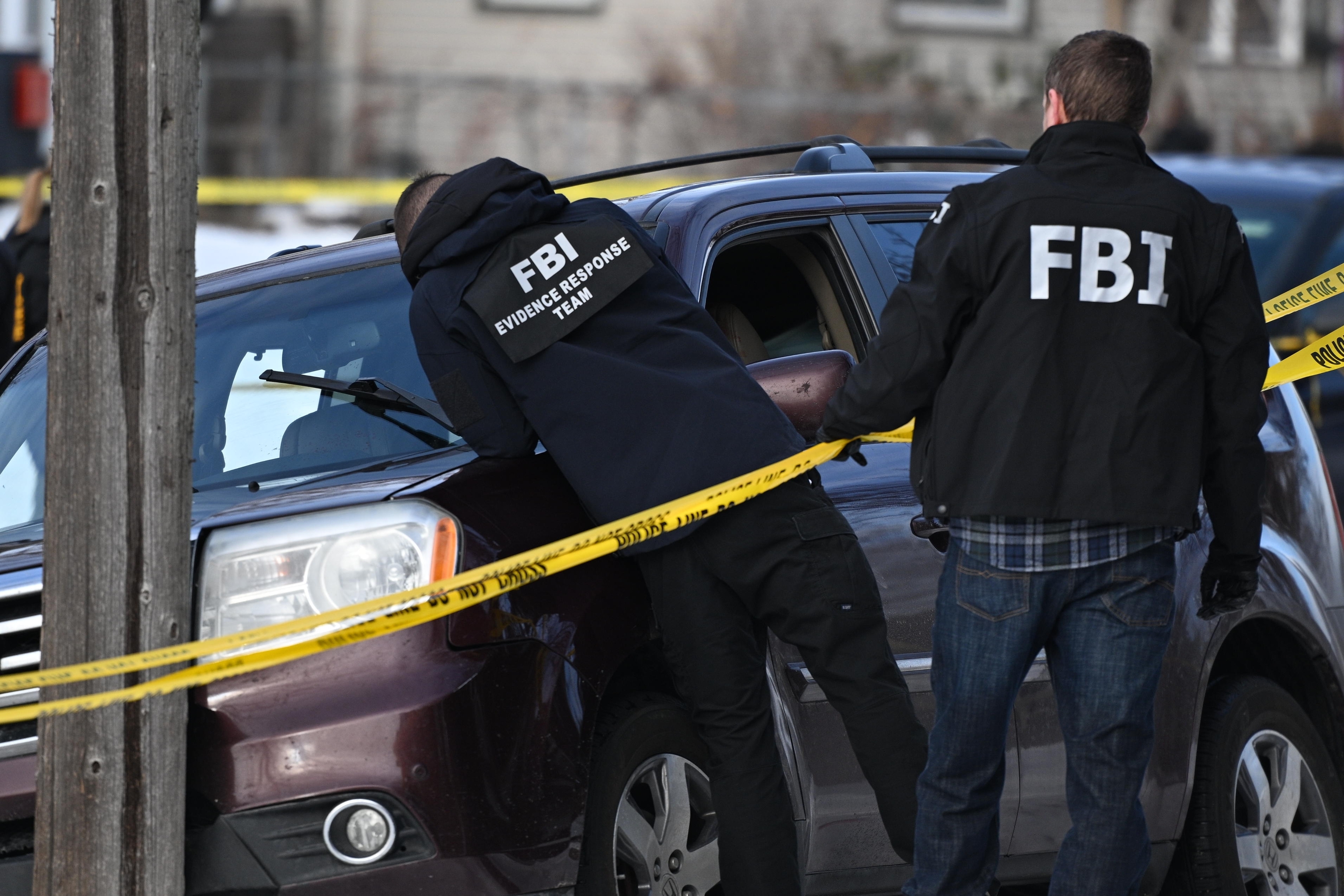 Law enforcement officers attend to the scene of the shooting involving federal law enforcement agents, Wednesday, in Minneapolis.