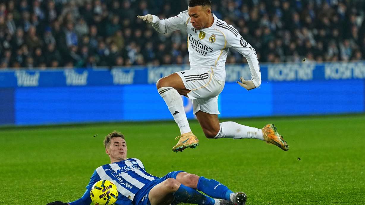 Real Madrid's Kylian Mbappe, top, challenges for the ball during the Spanish La Liga soccer match between Alaves and Real Madrid in Vitoria-Gasteiz, Spain, Sunday, Dec. 14, 2025.