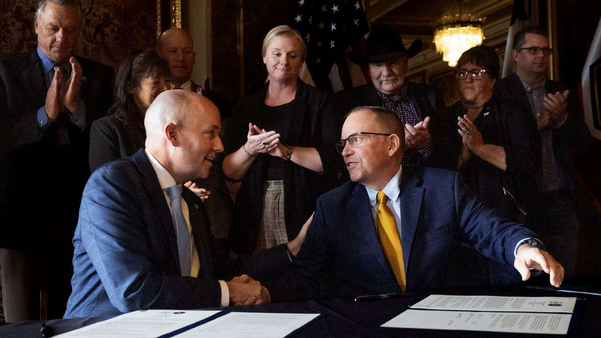 Utah Gov. Spencer Cox and Tom Schultz, chief of the U.S. Department of Agriculture Forest Service, sign a cooperative agreement at the state Capitol in Salt Lake City on Thursday.
