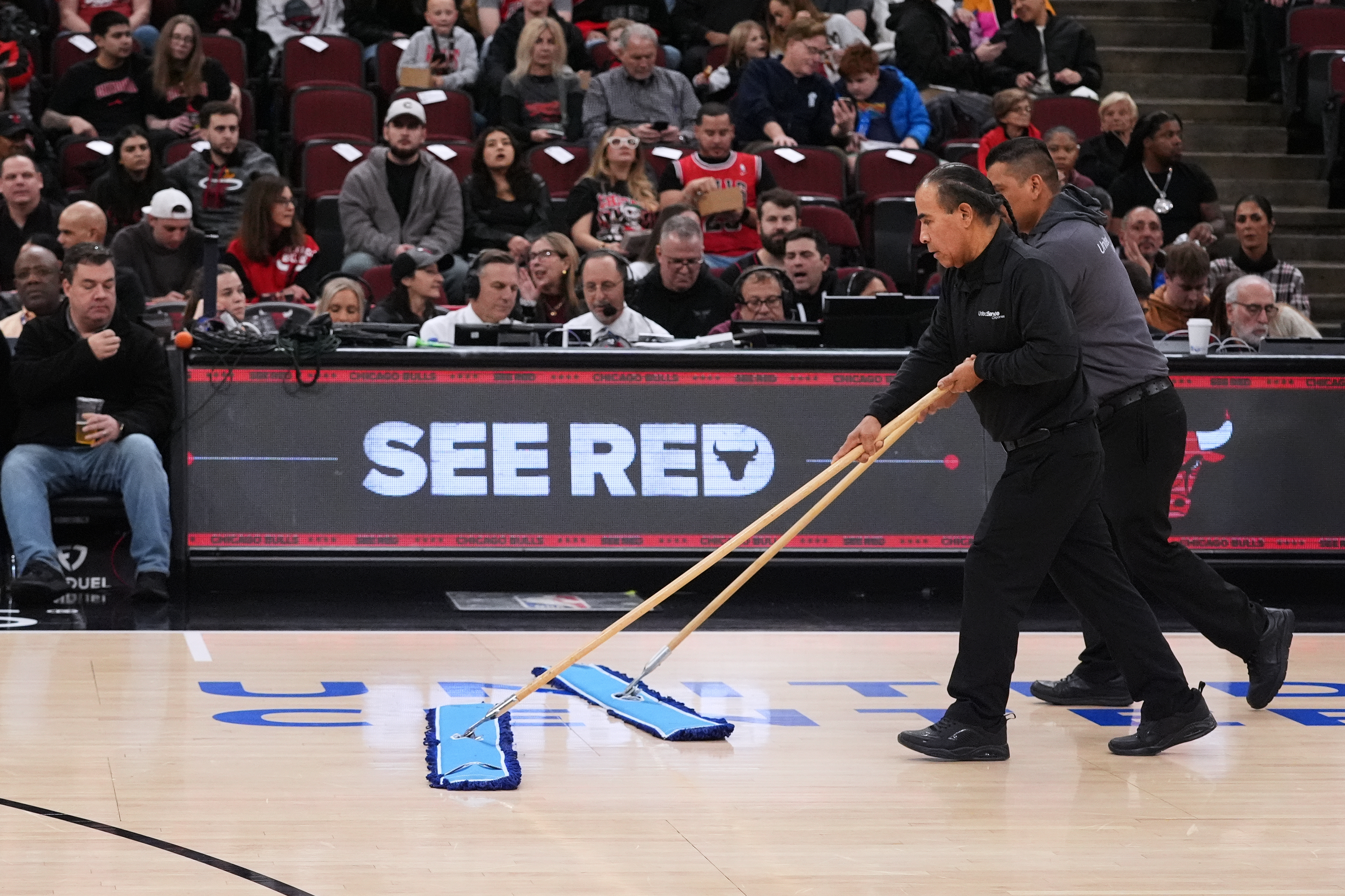 United center employees clean the court during a delay before an NBA basketball game against the Miami Heat in Chicago, Thursday, Jan. 8, 2026.