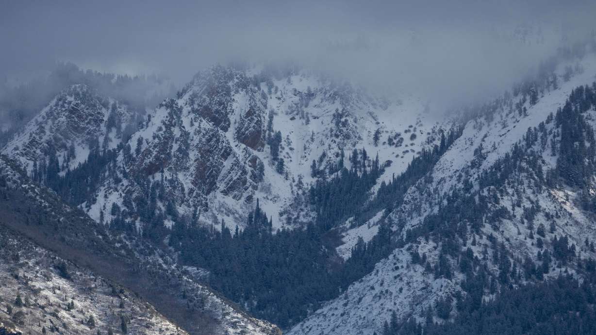 Clouds hang over the Wasatch Mountains, which are covered in fresh snow after a storm in Salt Lake City on Jan. 5. Utah Gov. Spencer Cox called for people of all faiths to pray for snow on Monday, as the state's snowpack remains well below normal.