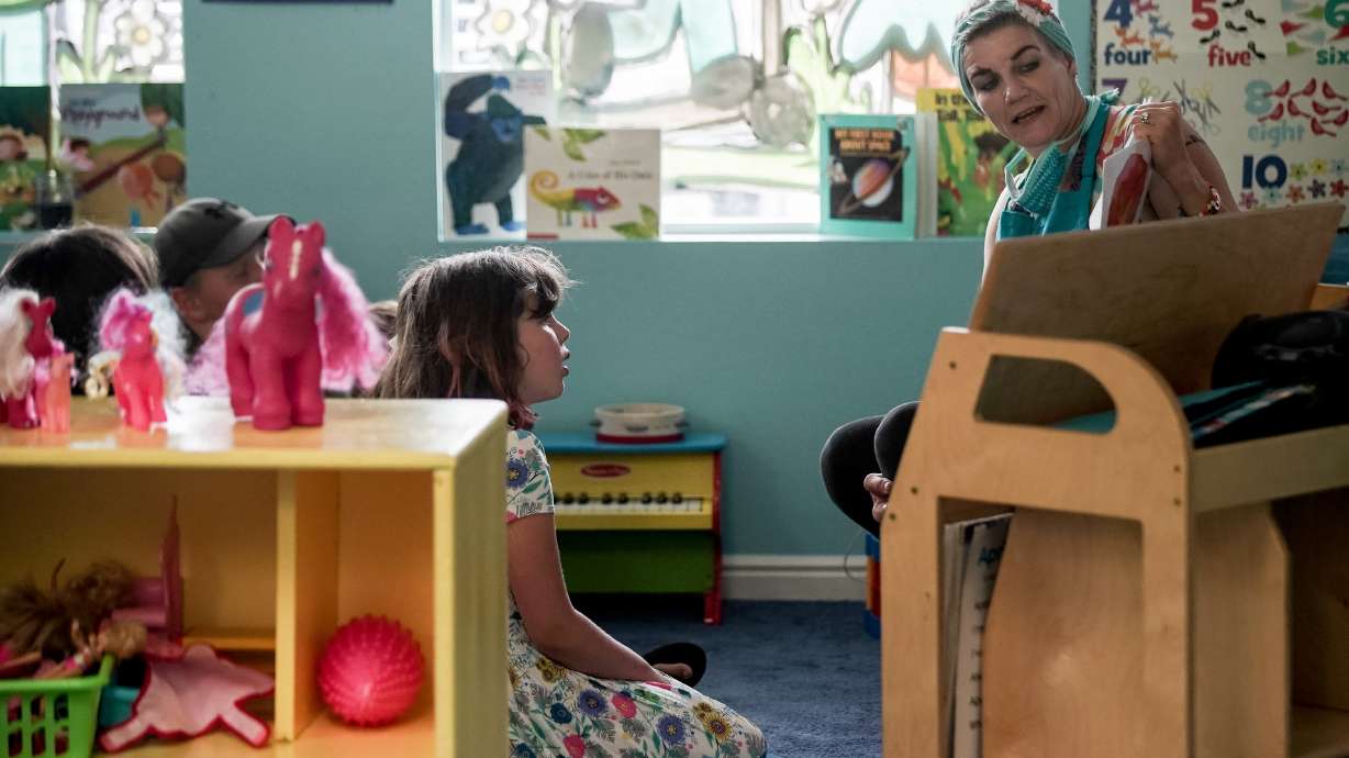 DiVina Warren reads to children at Sunshine Academy Preschool in Alpine on May 14, 2020. A new study finds more can be done to expand child care options and empower women in Utah's workplace.