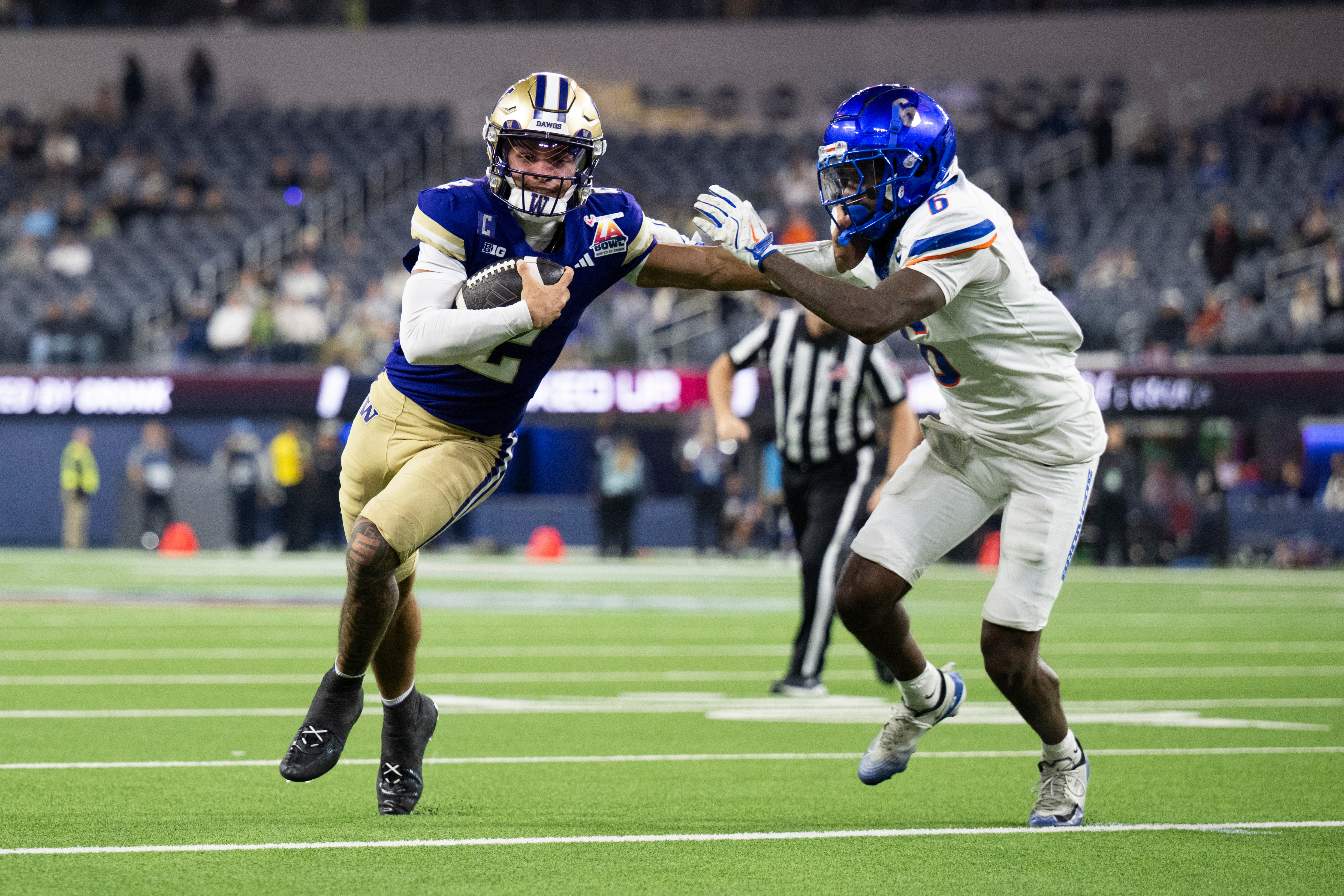 Washington quarterback Demond Williams Jr. (2) applies stiff arm to Boise State defensive back Jeremiah Earby (6) during the second half of the LA Bowl NCAA college football game Saturday, Dec. 13, 2025, in Inglewood, Calif.
