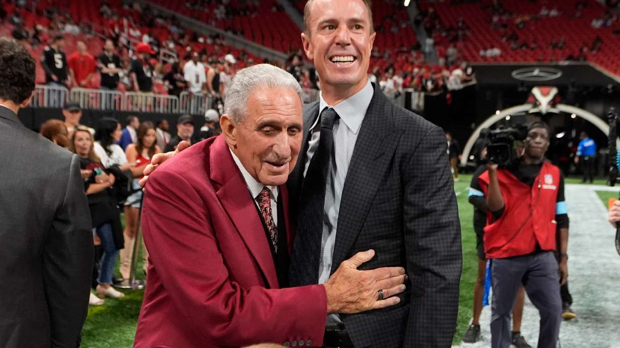 FILE - Atlanta Falcons owner Arthur Blank, left, talks to former quarterback Matt Ryan before an NFL football game against the Tampa Bay Buccaneers Oct. 3, 2024, in Atlanta.