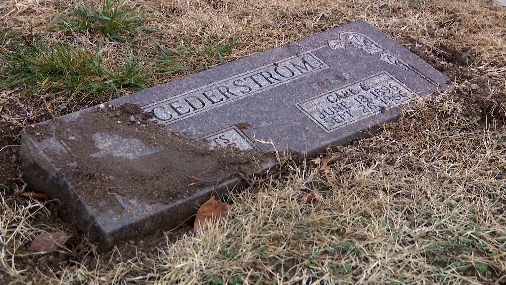 Several headstones at the Salt Lake Cemetery are shown visibly sunken, tilted or covered by displaced soil.