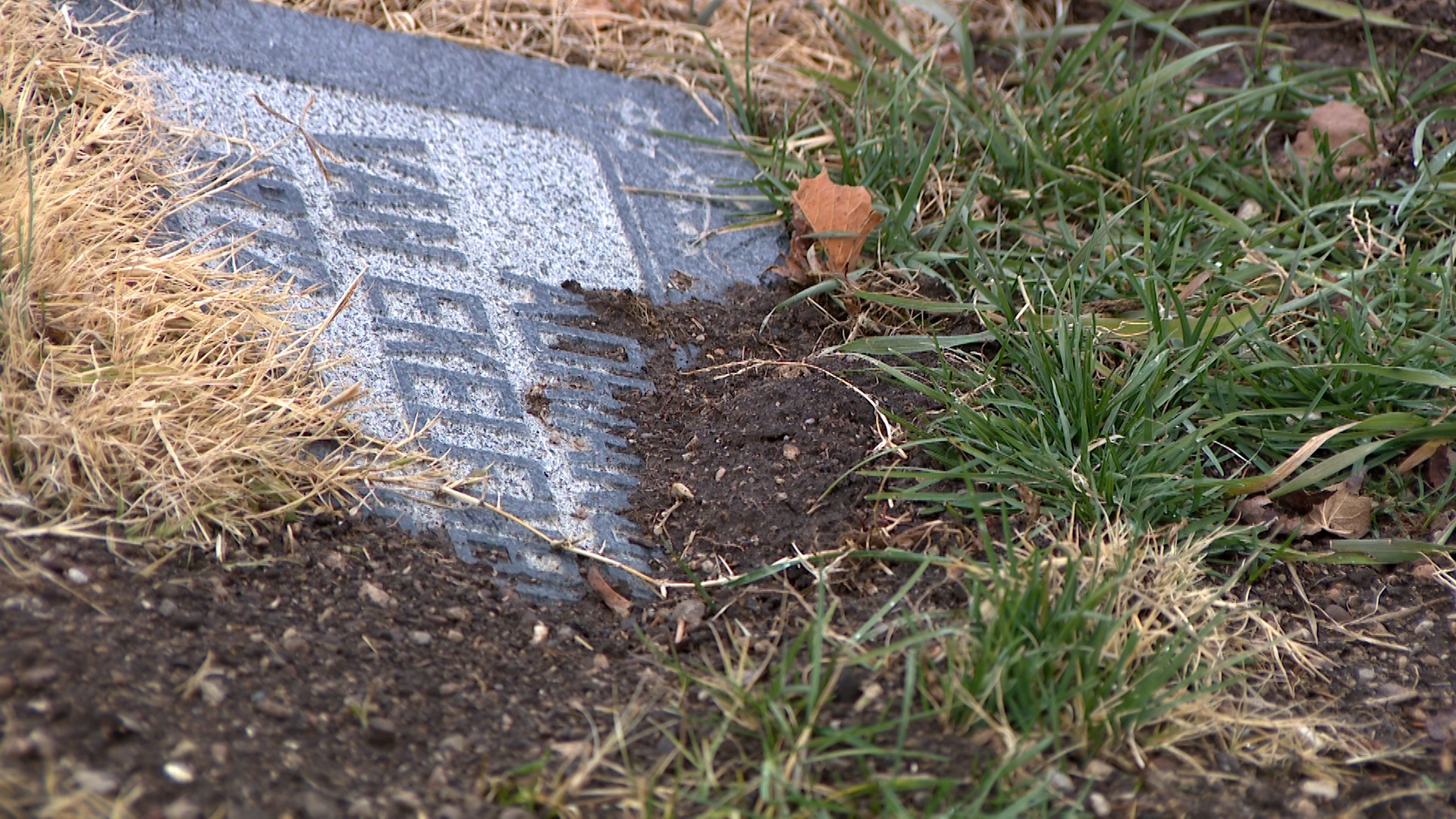 Several headstones at the Salt Lake Cemetery are shown visibly sunken, tilted or covered by displaced soil.