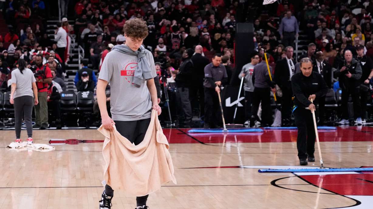 United Center employees try to dry the court before an NBA basketball game between the Miami Heat and the Chicago Bulls in Chicago, Thursday, Jan. 8, 2026.
