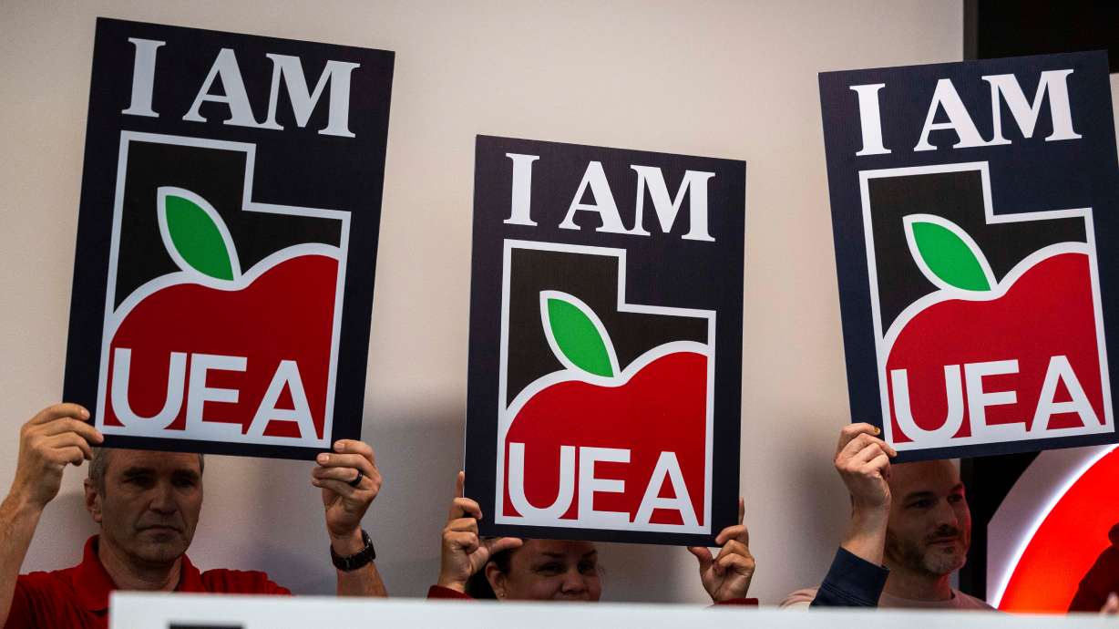 Utah Education Association signs are held up during a press conference discussing the UEA’s 2025 priorities during a press conference in Murray, Monday. A member of the Utah State Board of Education filed a lawsuit against the UEA on Monday.