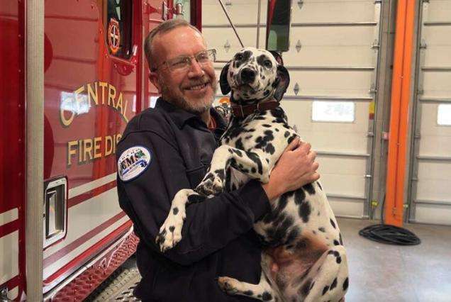 Nathan Bronson poses with Polka inside the Menan Fire Station.