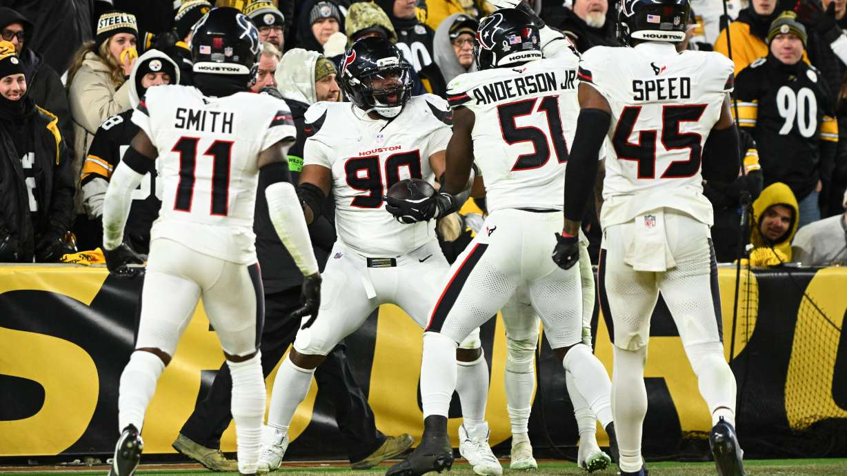 Houston Texans defensive tackle Sheldon Rankins (90) celebrates with cornerback Tremon Smith (11), defensive end Will Anderson Jr. (51) and linebacker E.J. Speed (45) after a touchdown during the second half of an NFL wild-card playoff football game against the Pittsburgh Steelers, Monday, Jan. 12, 2026, in Pittsburgh.