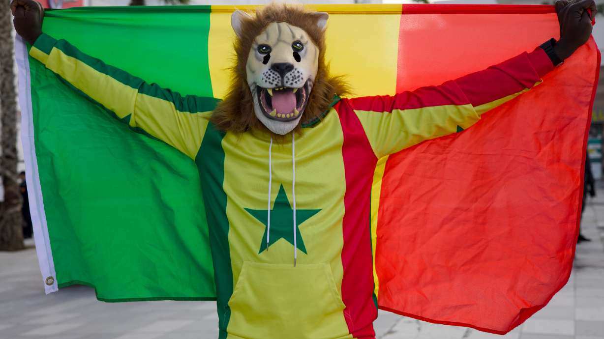 Senegal fan Pape, dressed as a lion, holds the Senegal flag at the Africa Cup of Nations in Tangier, Morocco, Dec. 23, 2025.