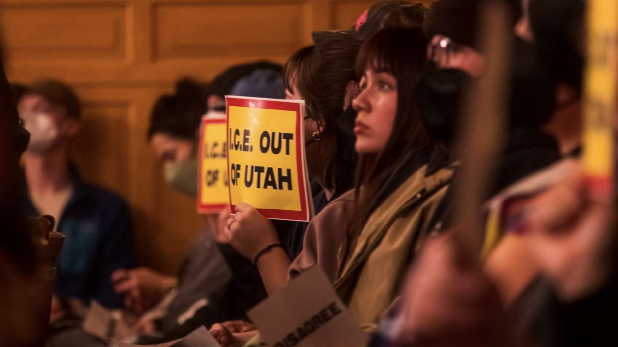 People hold up signs protesting ICE during a Salt Lake City Council meeting at the Salt Lake City-County Building Tuesday. Over 100 people attended to voice concerns about Immigration and Customs Enforcement and any potential ties with the city.