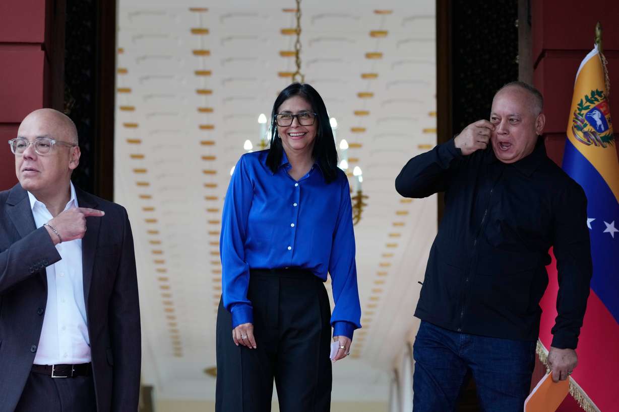 Venezuela's acting President Delcy Rodriguez, center, smiles flanked by Interior Minister Diosdado Cabello, right, and National Assembly President, her brother, Jorge Rodriguez, as they prepare ot make a statement in Caracas, Venezuela, Wednesday.