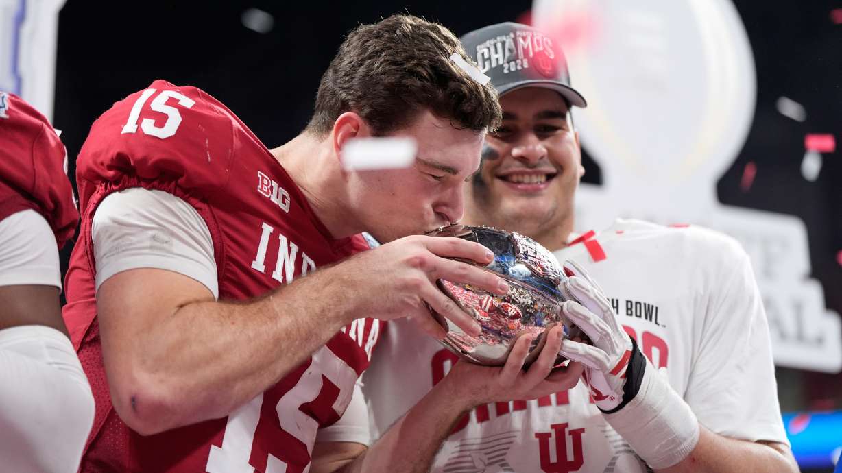 Indiana quarterback Fernando Mendoza (15) kisses the trophy after the Peach Bowl NCAA college football playoff semifinal against Oregon, Friday, Jan. 9, 2026, in Atlanta.